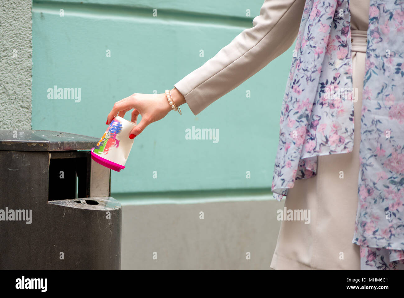 A woman throws a paper cup in the rubbish bin Stock Photo - Alamy
