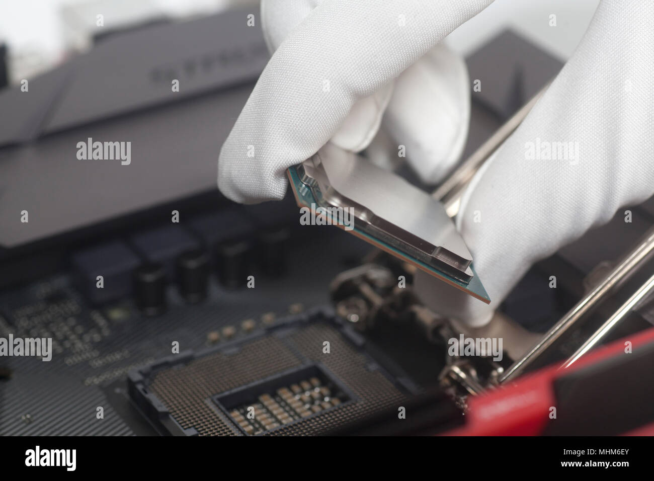 Computer technician wearing white gloves installing CPU into