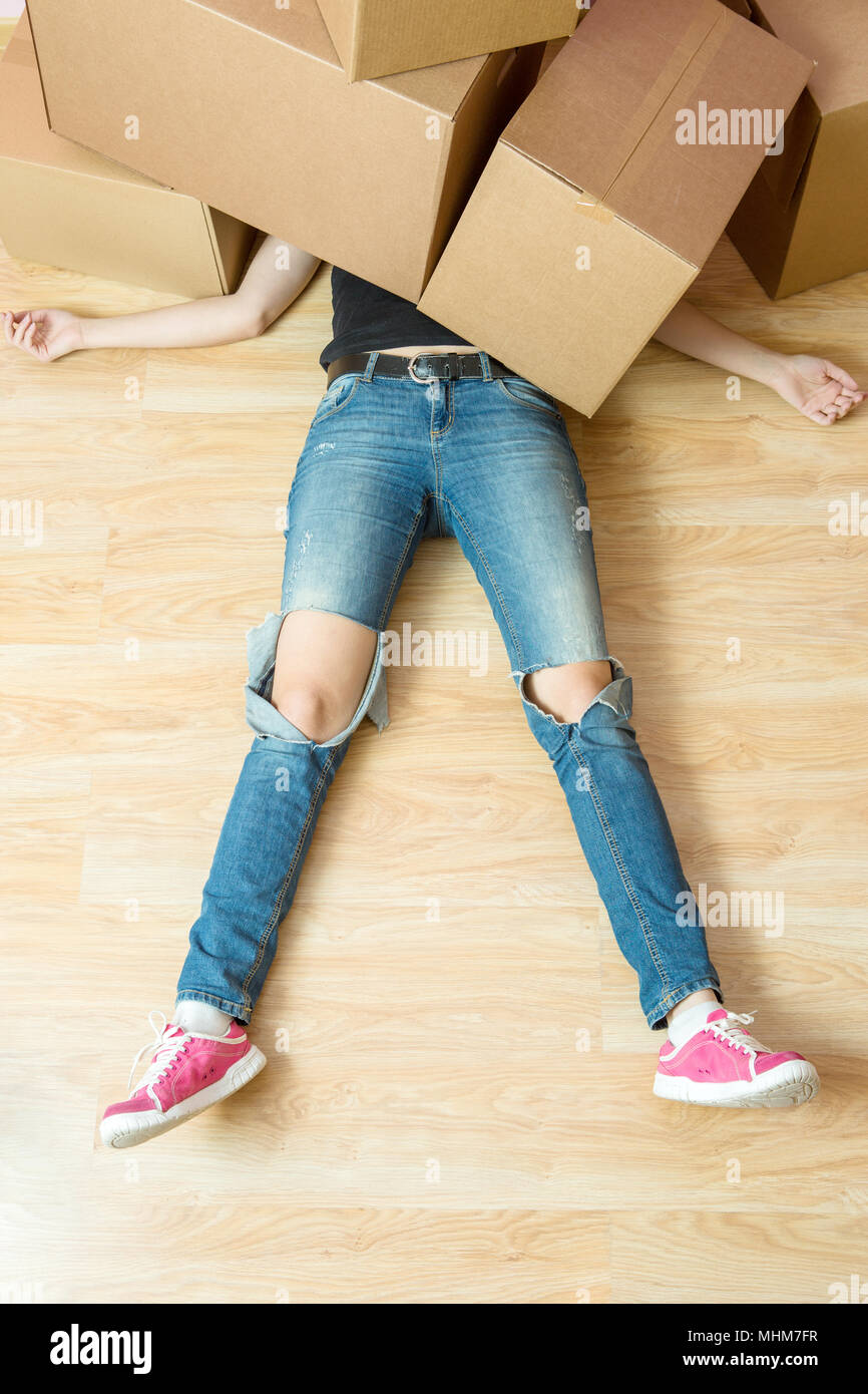 Image of woman in jeans lying under cardboard boxes Stock Photo Alamy