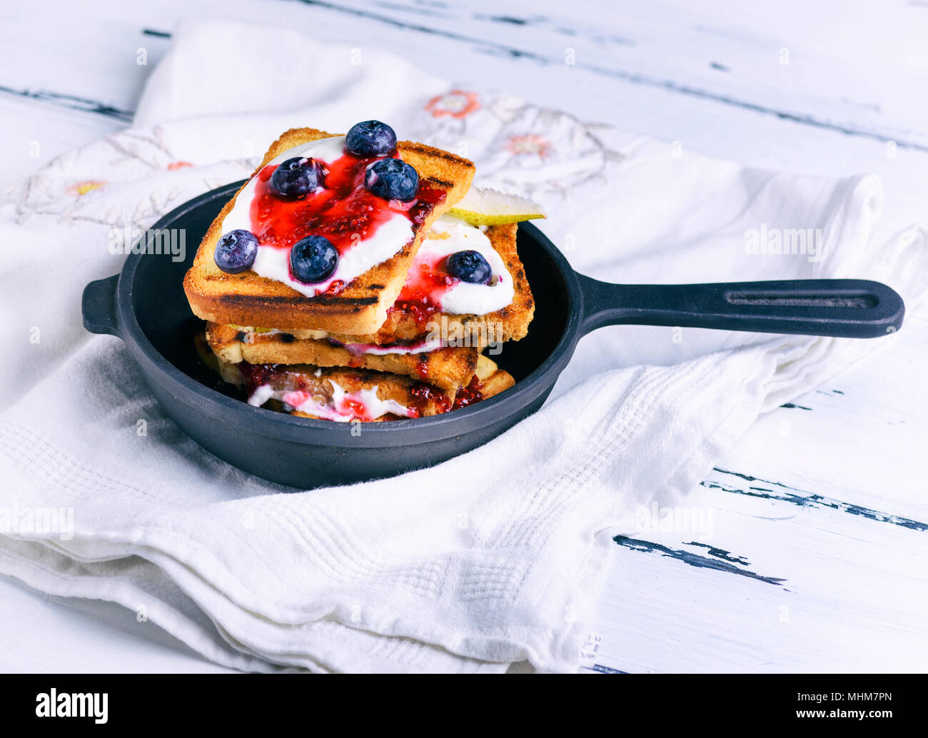 French Toast With Berries Syrup And Sour Cream In A Black Cast Iron Frying Pan Stock Photo Alamy