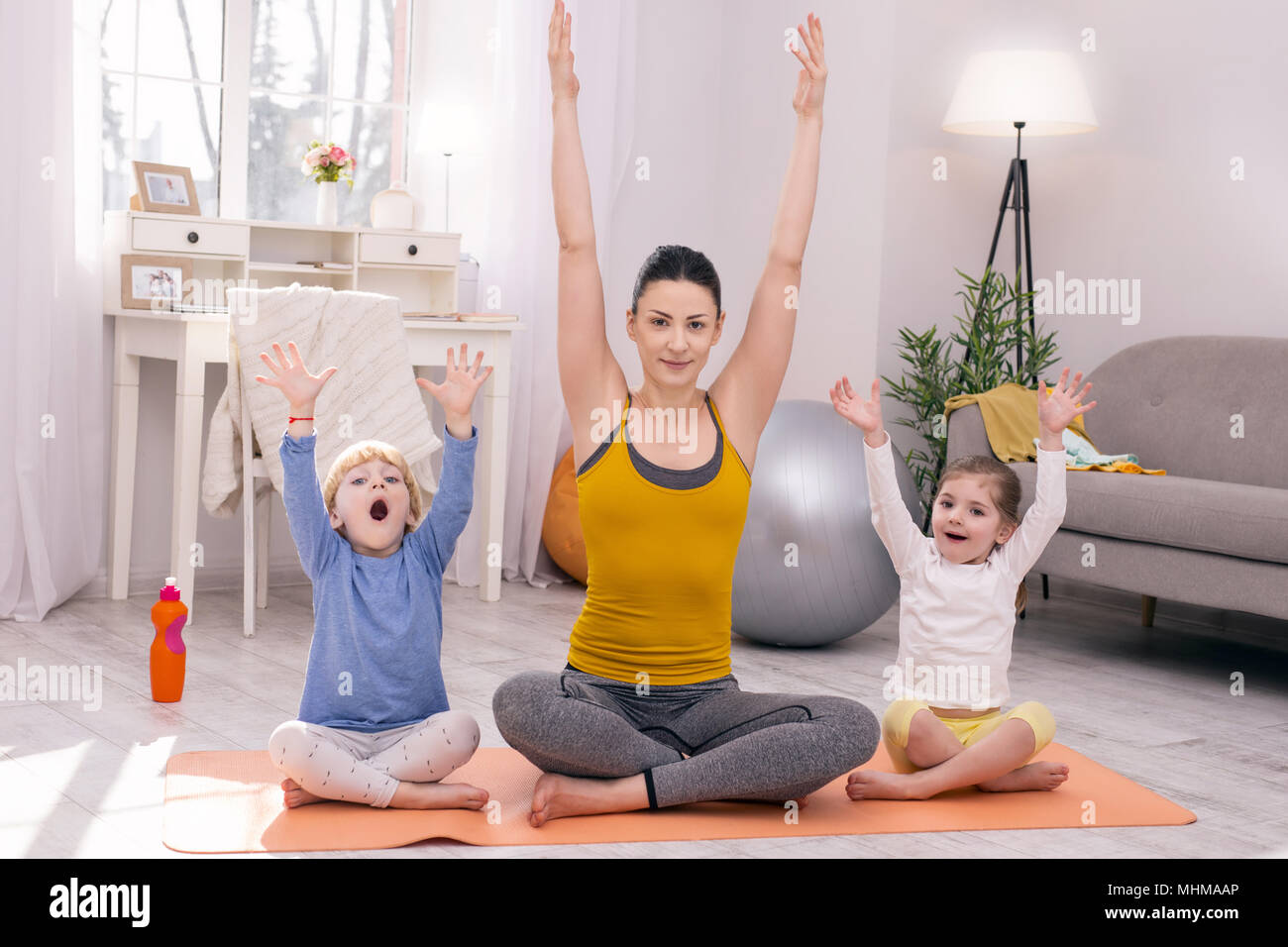 Joyful mother and her children doing yoga Stock Photo Alamy