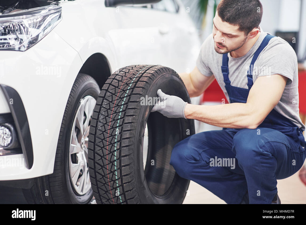 Mechanic holding a tire tire at the repair garage. replacement of
