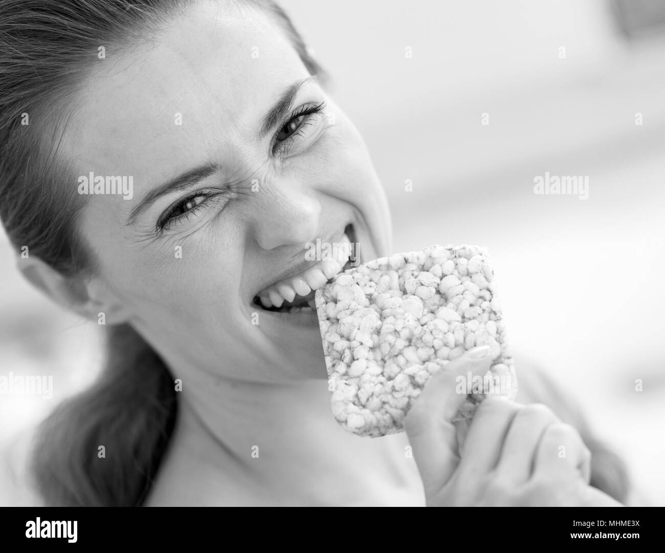 Happy young woman eating crisp bread Stock Photo