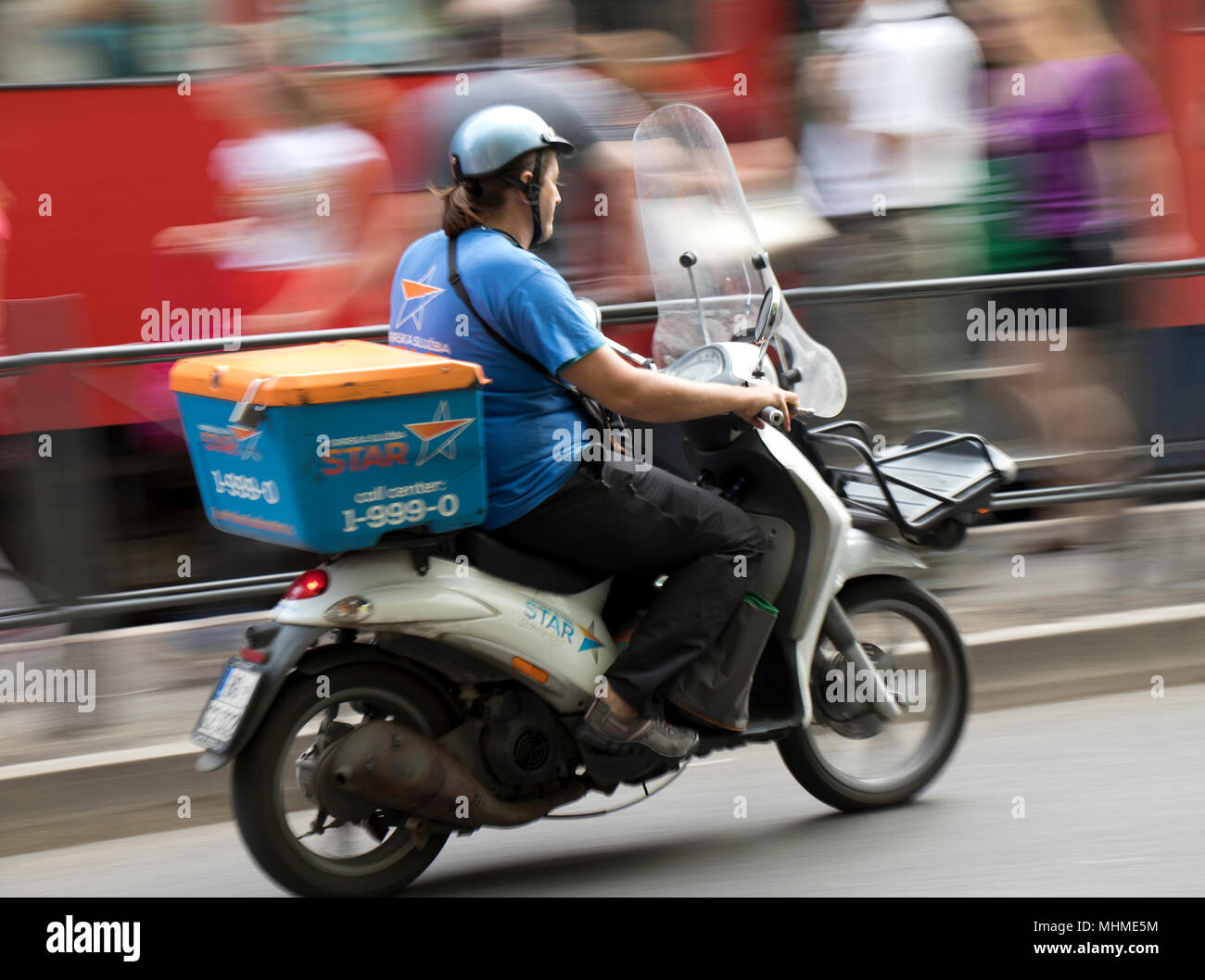 Belgrade, Serbia- April 24, 2018:l Man from city courier delivery service riding a scooter on busy street Stock Photo