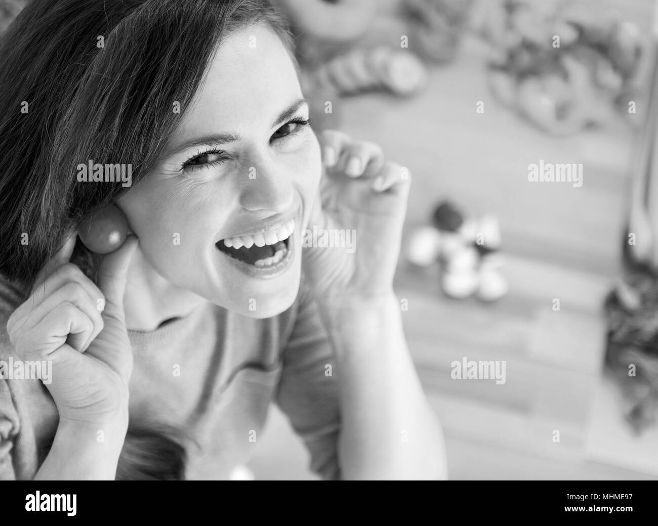 Smiling young woman using cherry tomatos as earring Stock Photo