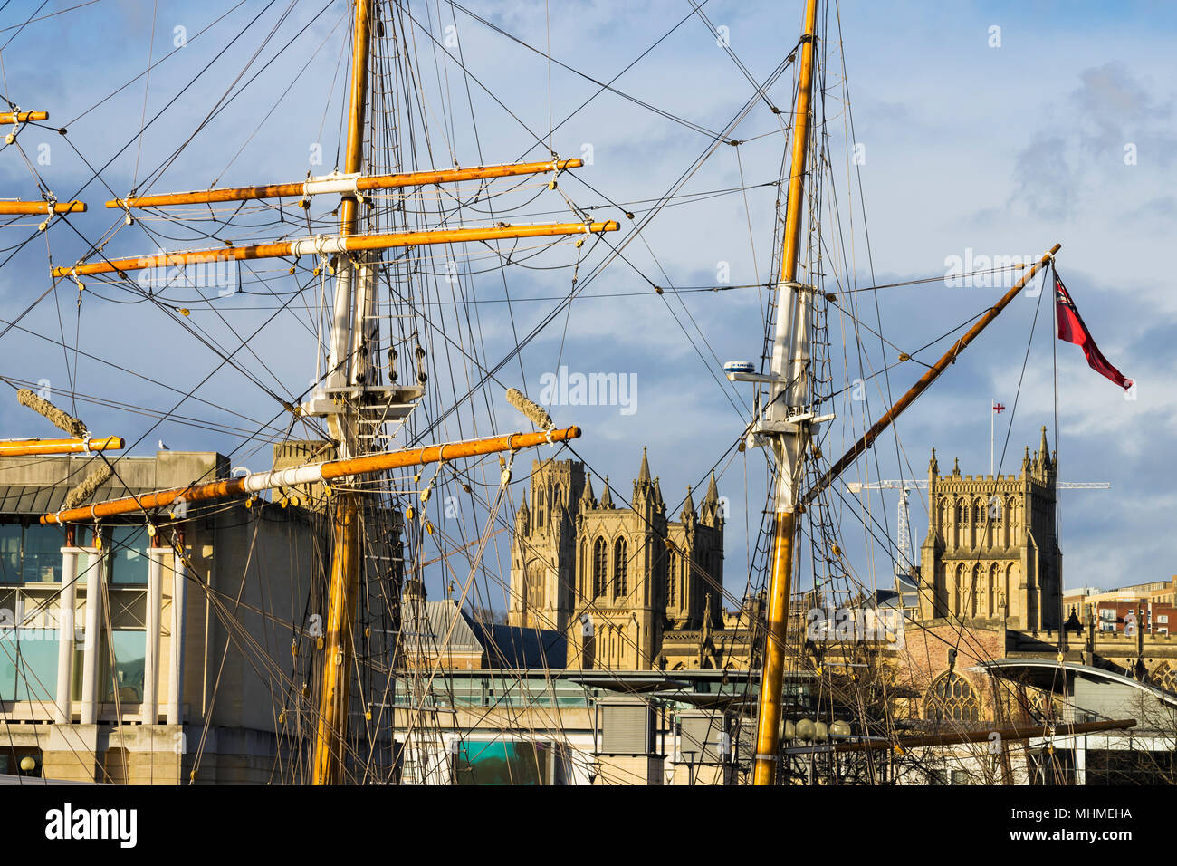 Bristol Cathedral - The Cathedral Church of the Holy and Undivided Trinity -framed by the masts of the Tall Ship Kaskelot, Bristol, England Stock Photo