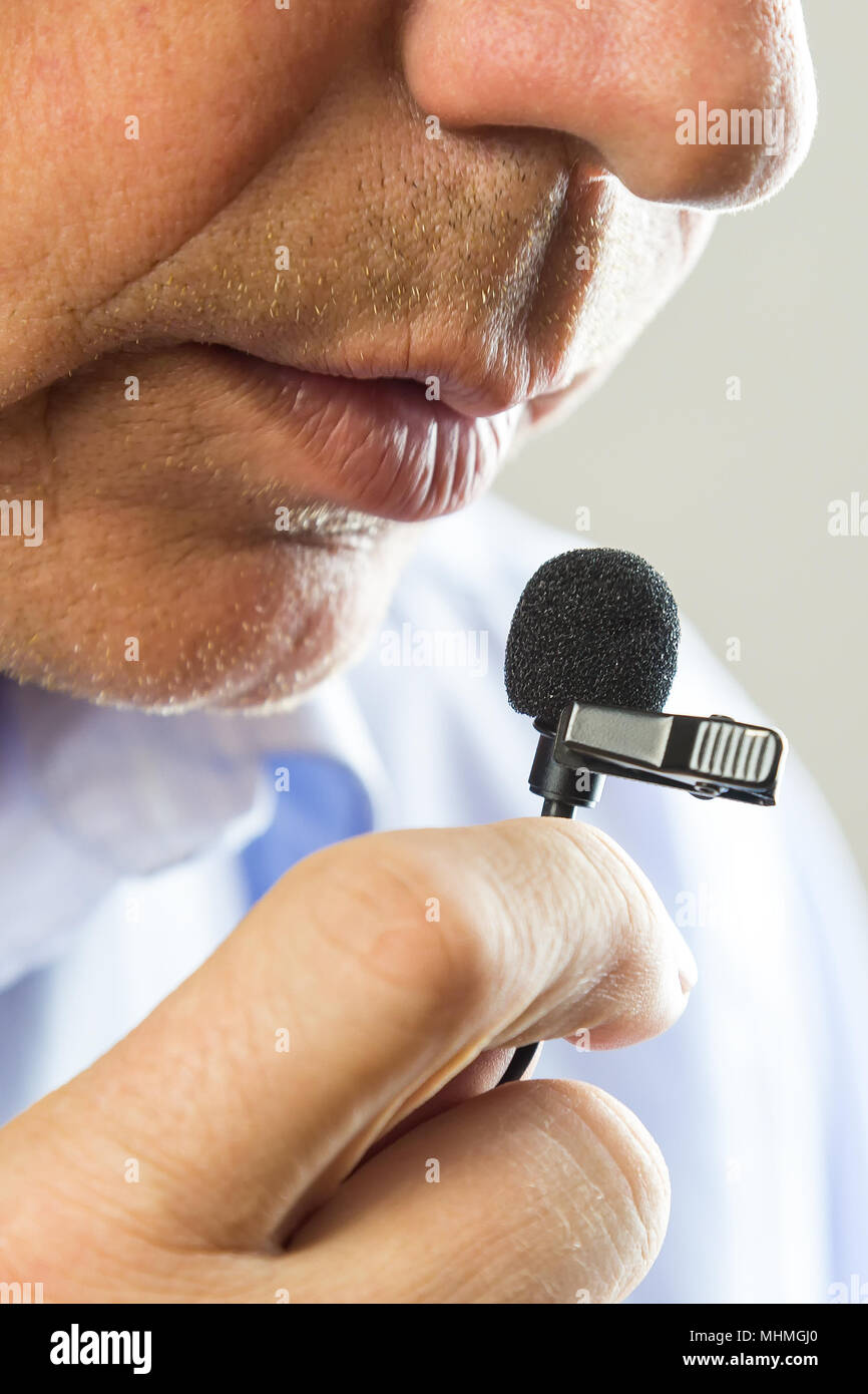 The lips of a man speak loudly in a whisper into a lapel microphone Stock  Photo - Alamy