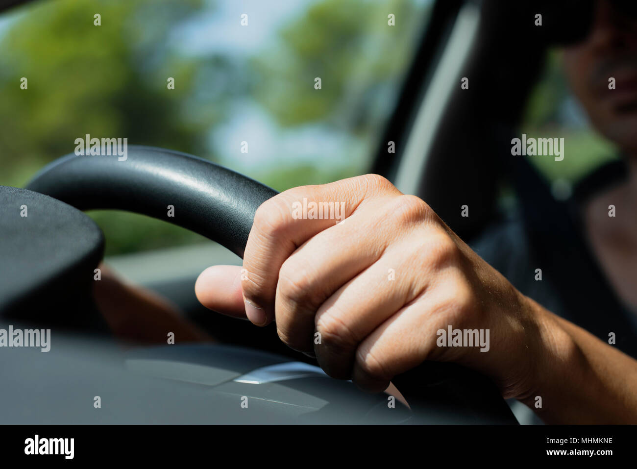 closeup of a young caucasian man using sunglasses driving a car Stock Photo