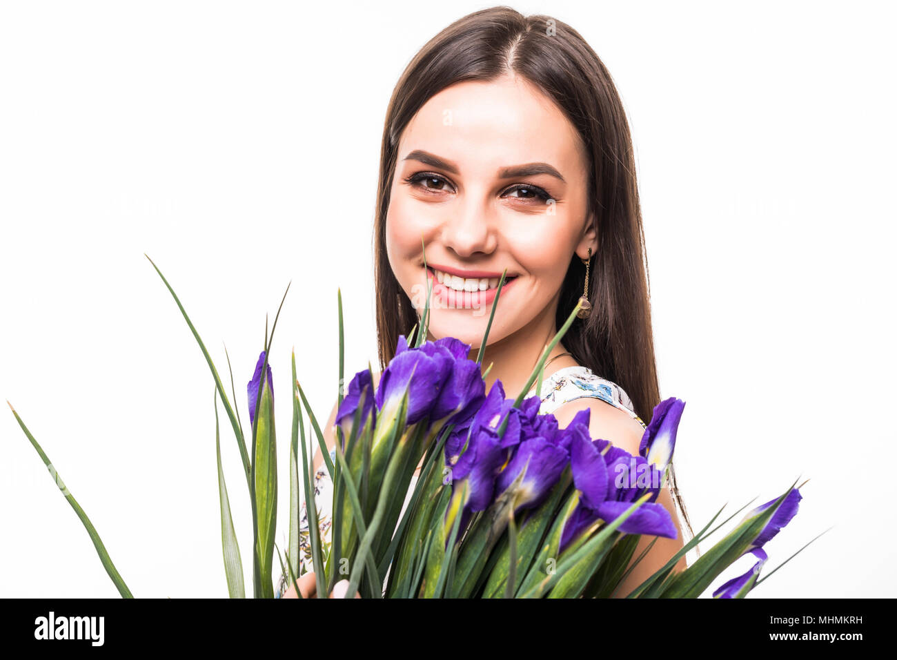 attractive young woman in dress holding iris flowers and looking at ...