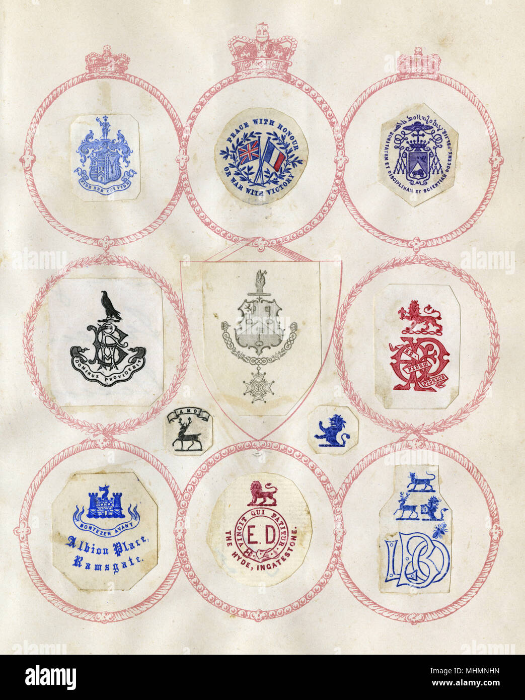 Loose page from a former scrapbook of crests and heraldry featuring family crests, coats of arms and many devices, shields, monograms and mottos!     Date: late 19th century Stock Photo