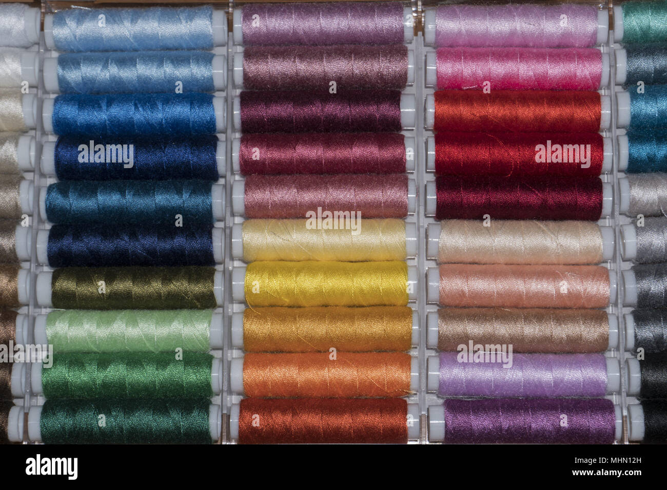 many different colors sewing Thread spools Stock Photo - Alamy
