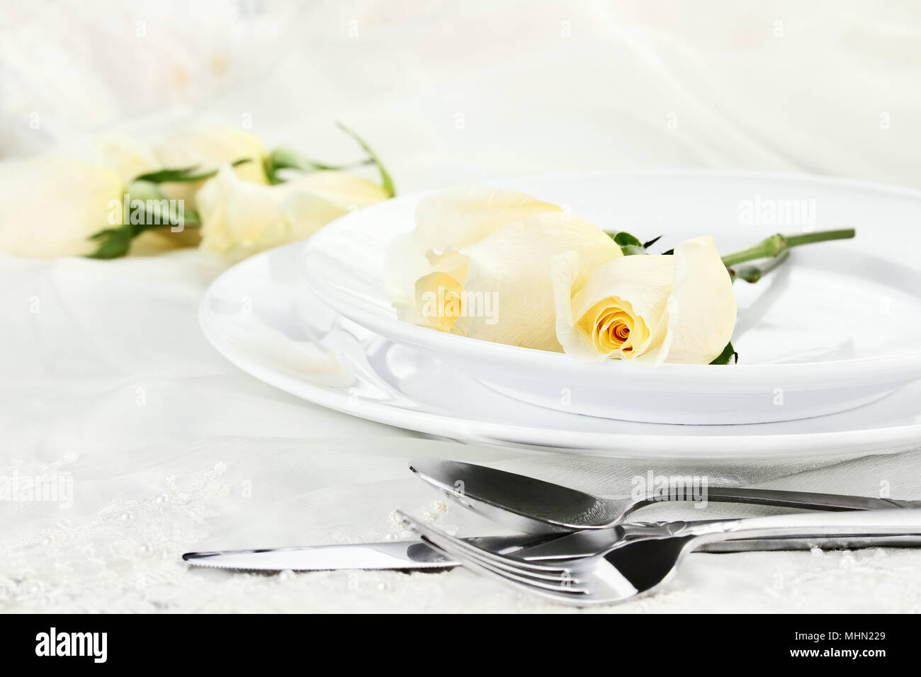 Romantic table setting with long stem yellow rose. Shallow depth of field. Stock Photo