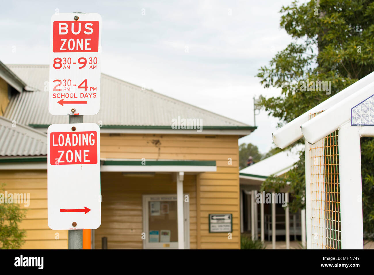 A bus zone and loading zone sign outside the public (Primary) school in the rural village of Nabiac on the mid north coast of NSW Australia. Stock Photo