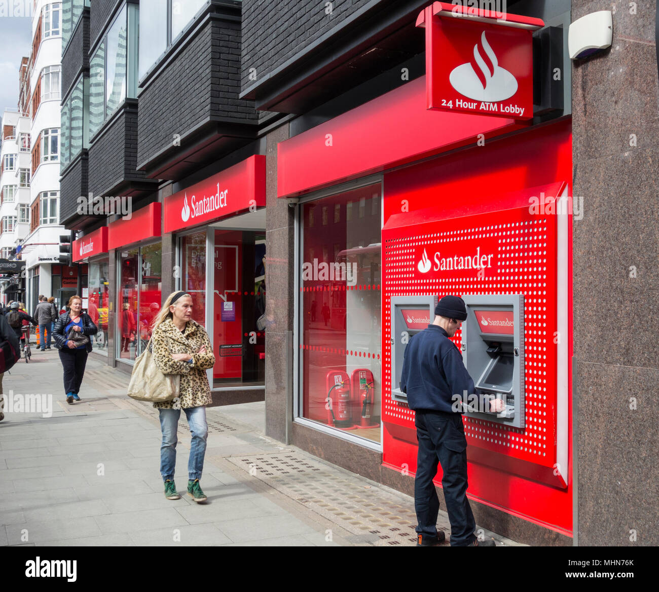 A man withdrawing cash from the Santander branch on Tottenham Court Road, Bloomsbury, London, W1, Stock Photo