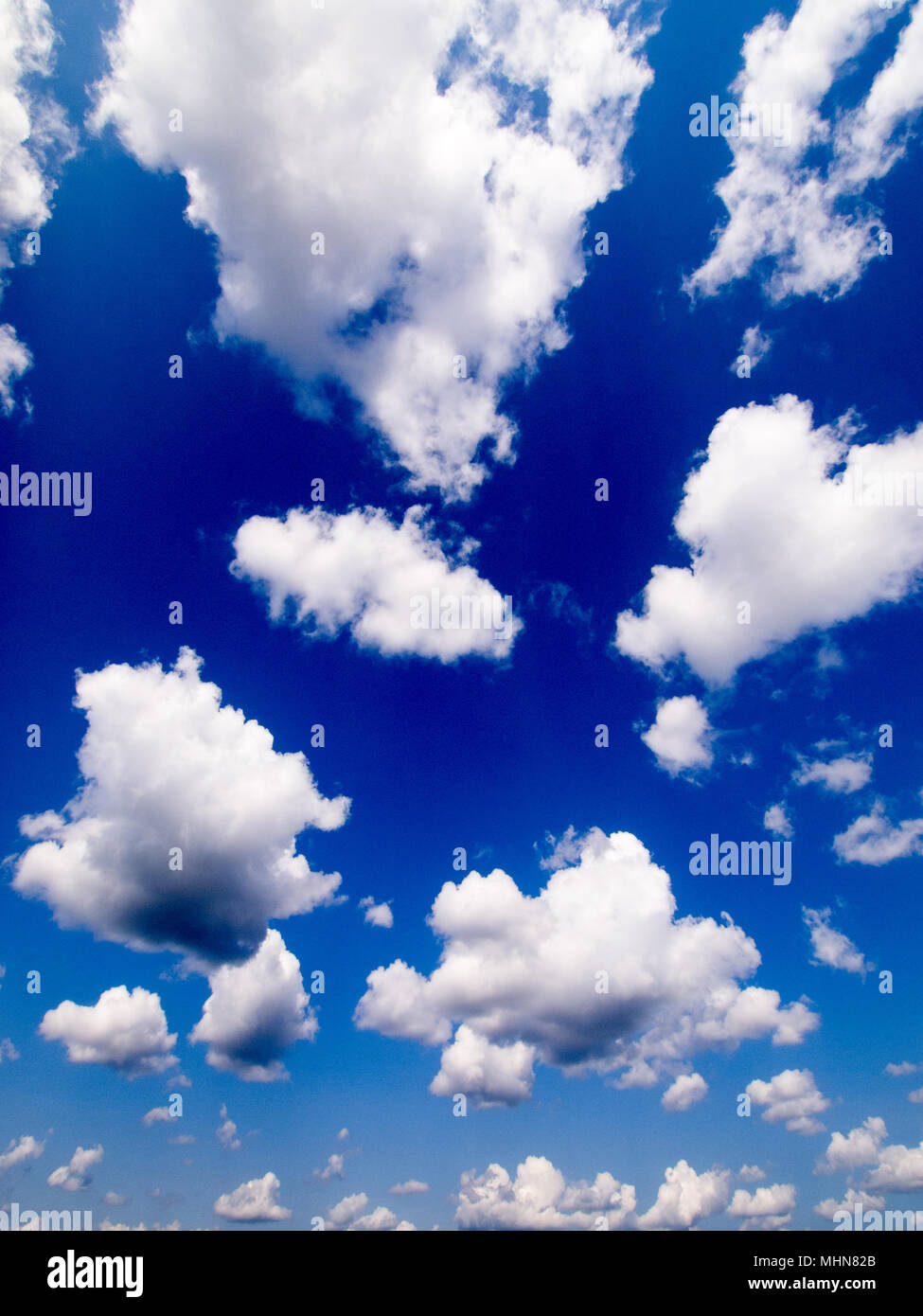 Blue sky with white fluffy clouds Stock Photo - Alamy