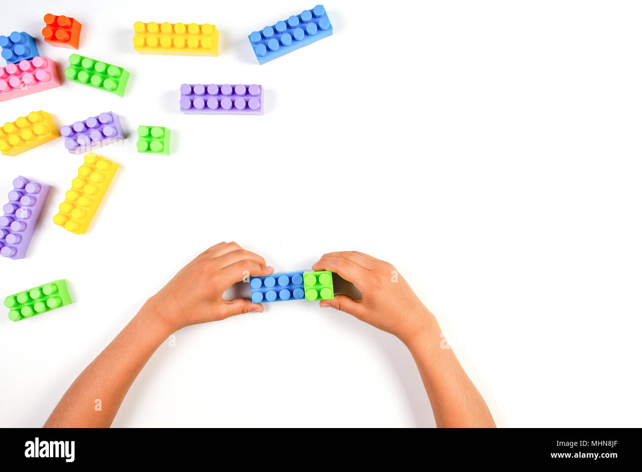 Kid hands with colorful plastic construction blocks on white background ...