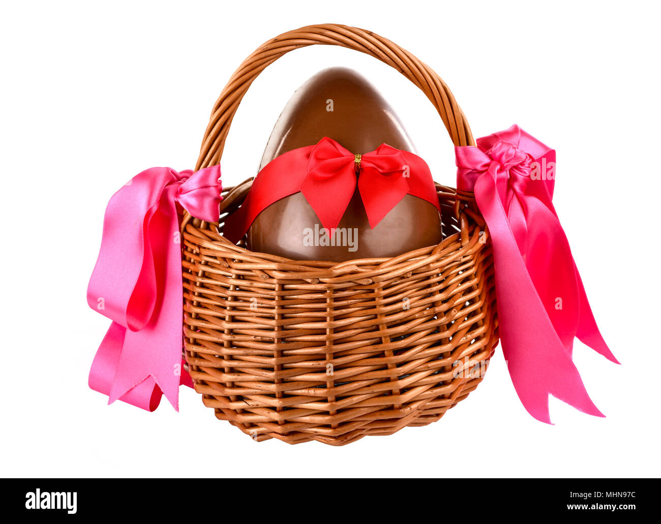 Unwrapped chocolate easter egg with bow in a wicker basket Stock Photo