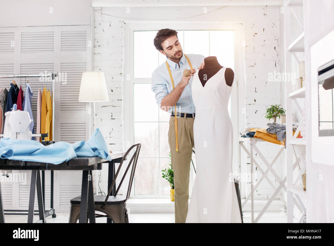 Happy tailor working on a new dress Stock Photo - Alamy