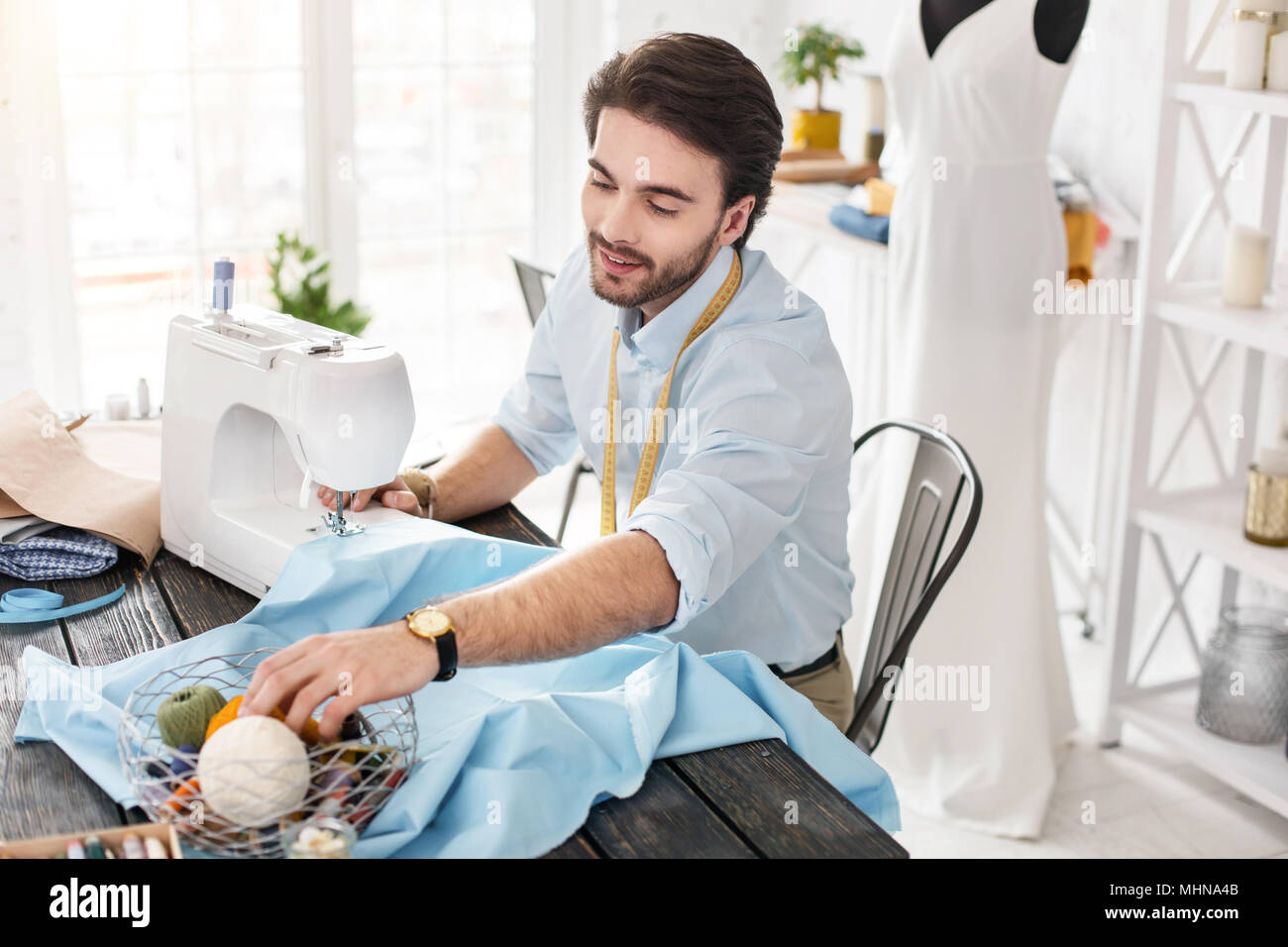 Gleeful tailor working on a sewing machine Stock Photo - Alamy