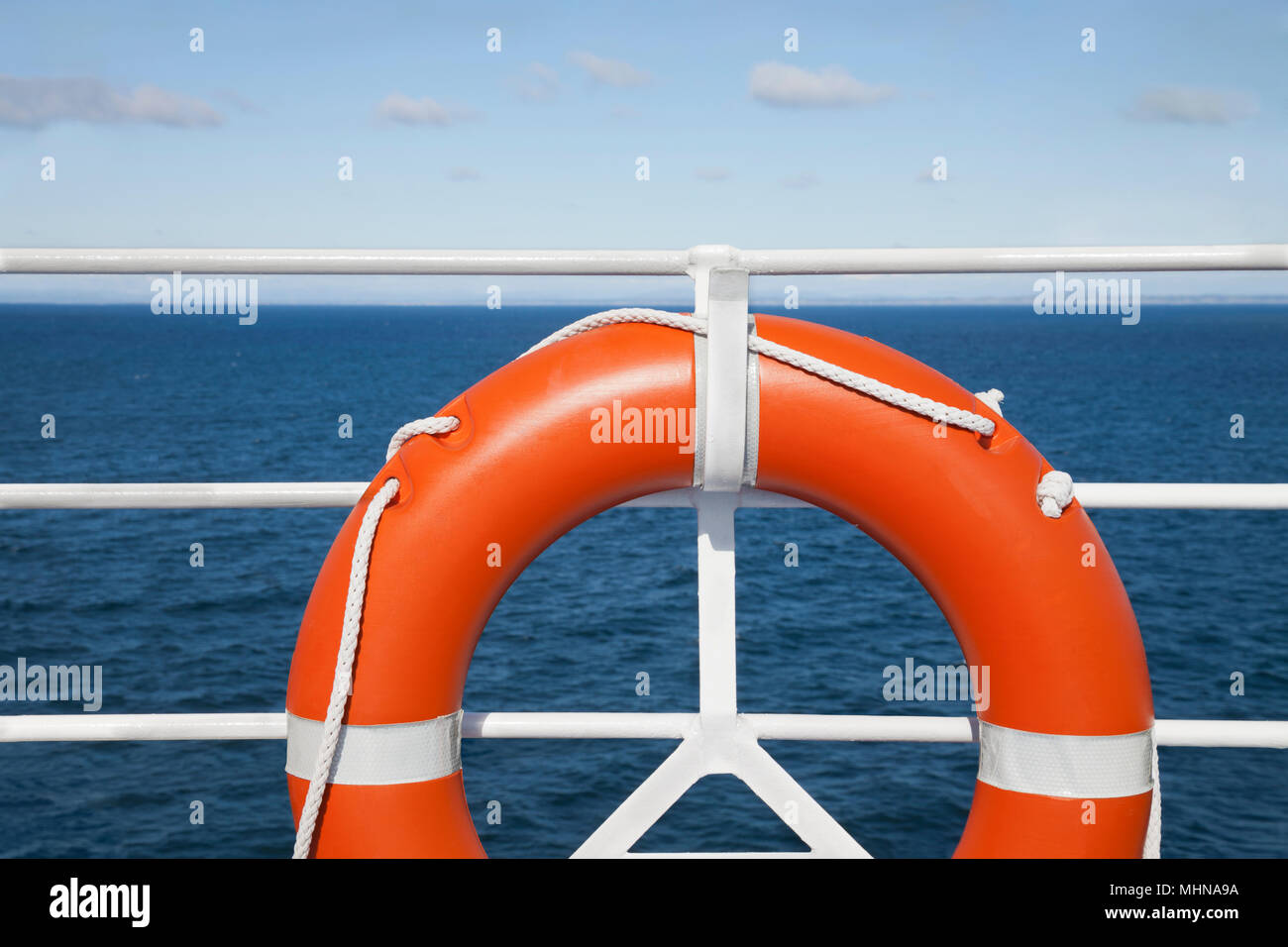 Lifebuoy and hand railing deck at cruise ship against seascape in a sunny day. Travel concept Stock Photo