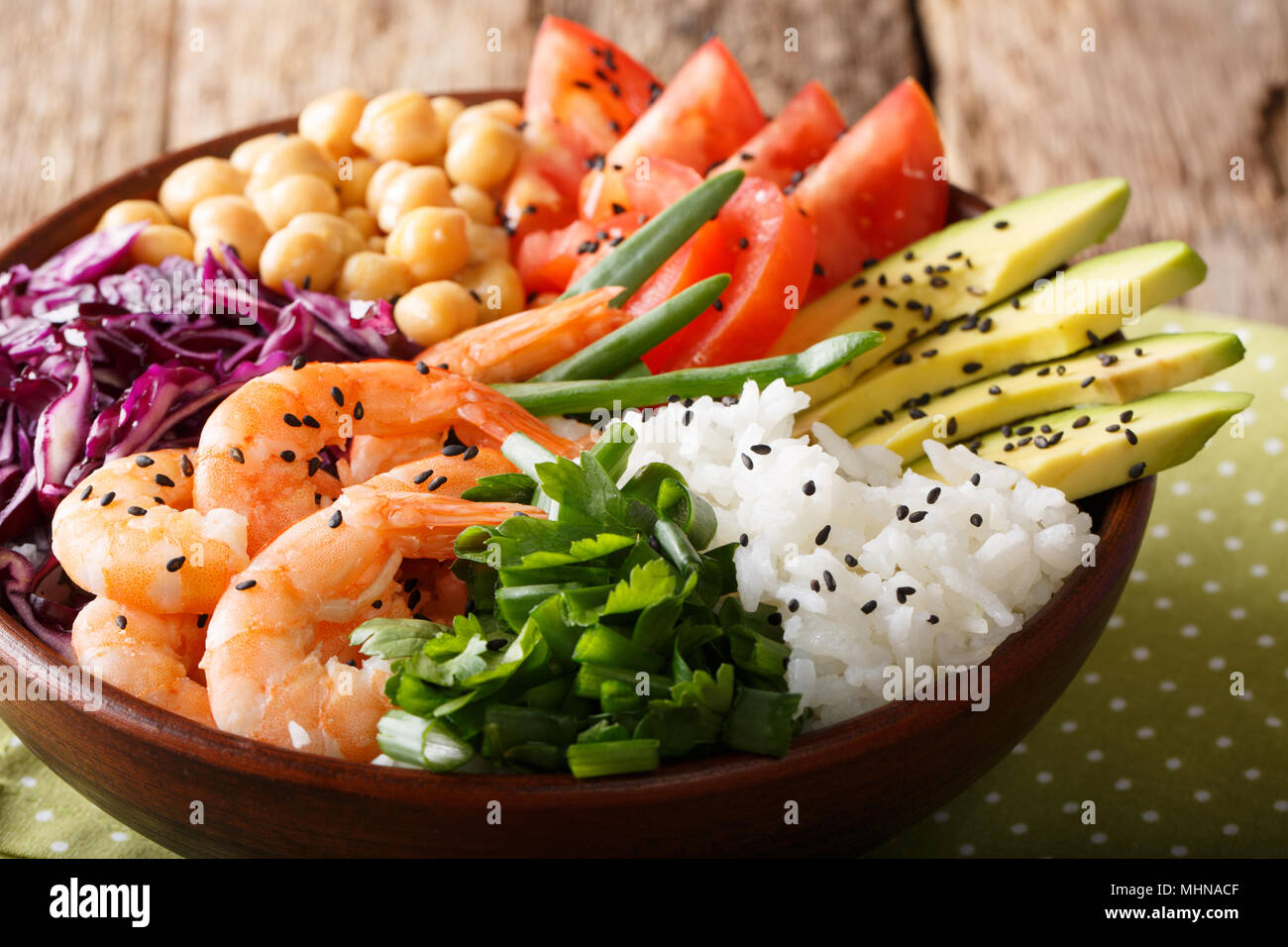 Organic Buddha bowl with prawns, red cabbage, tomatoes, avocado, chickpeas, rice and greens