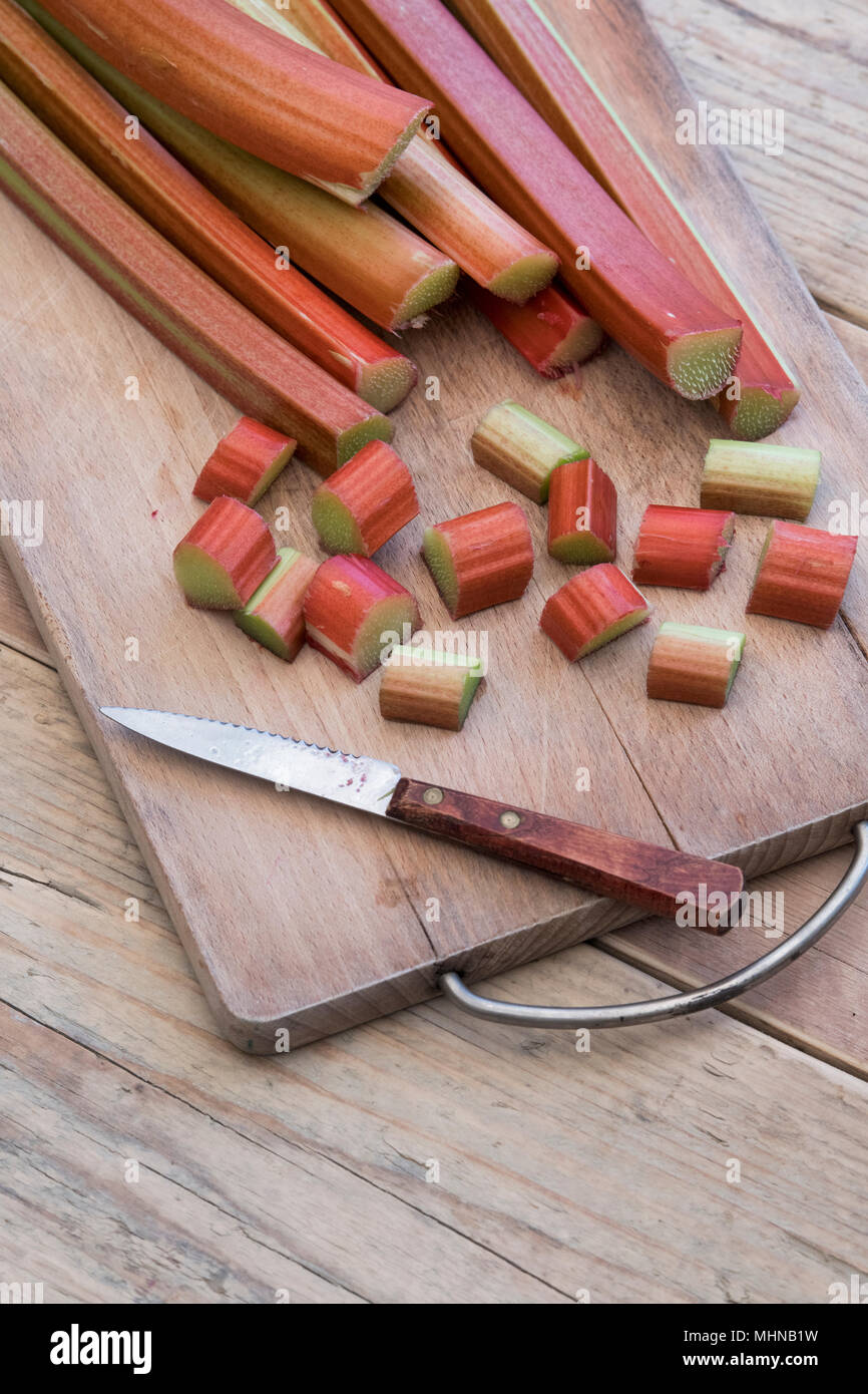 Rheum rhabarbarum. Chopped Rhubarb on a wooden board Stock Photo