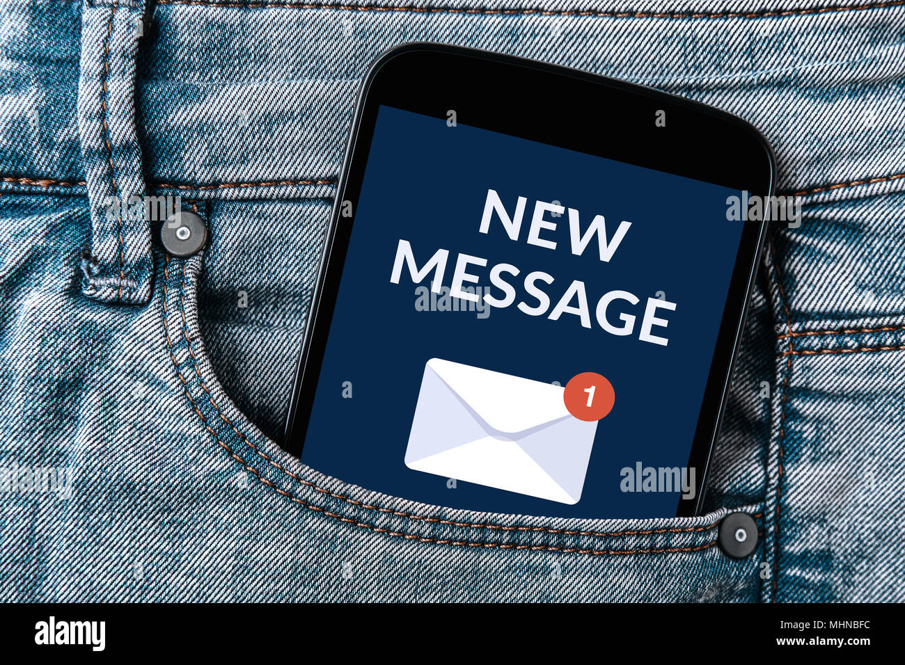New message notification concept on smartphone screen in jeans pocket. All screen content is designed by me. Stock Photo