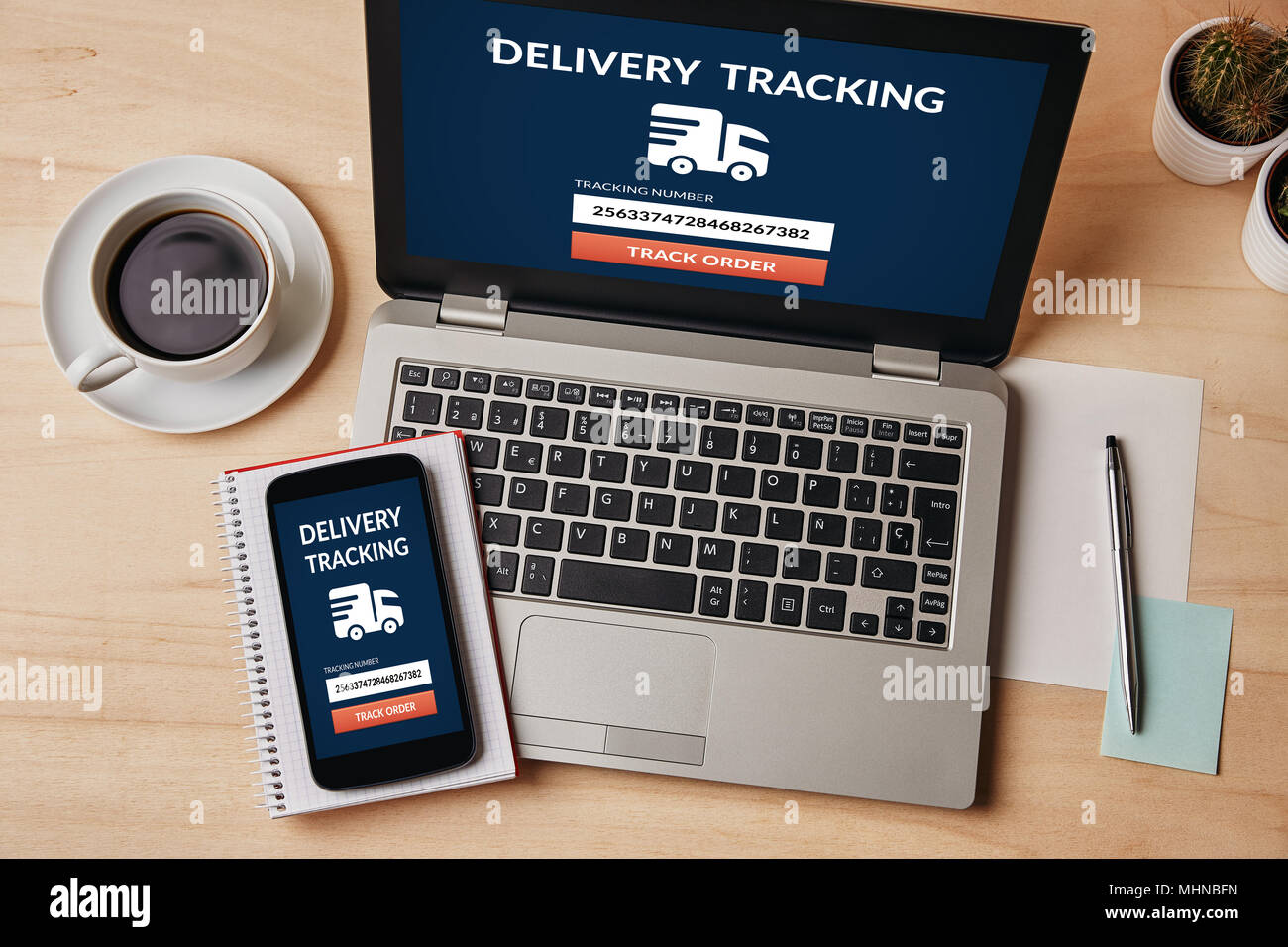 Delivery tracking concept on laptop and smartphone screen over wooden table. All screen content is designed by me. Flat lay Stock Photo