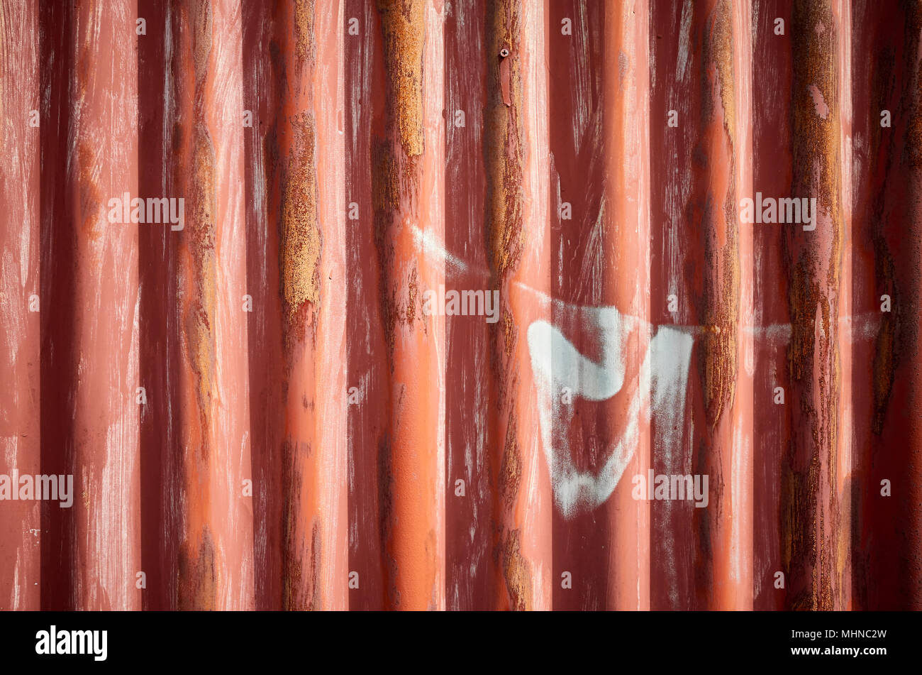 Weathered corrugated red rusty metal sheet, abstract background. Stock Photo
