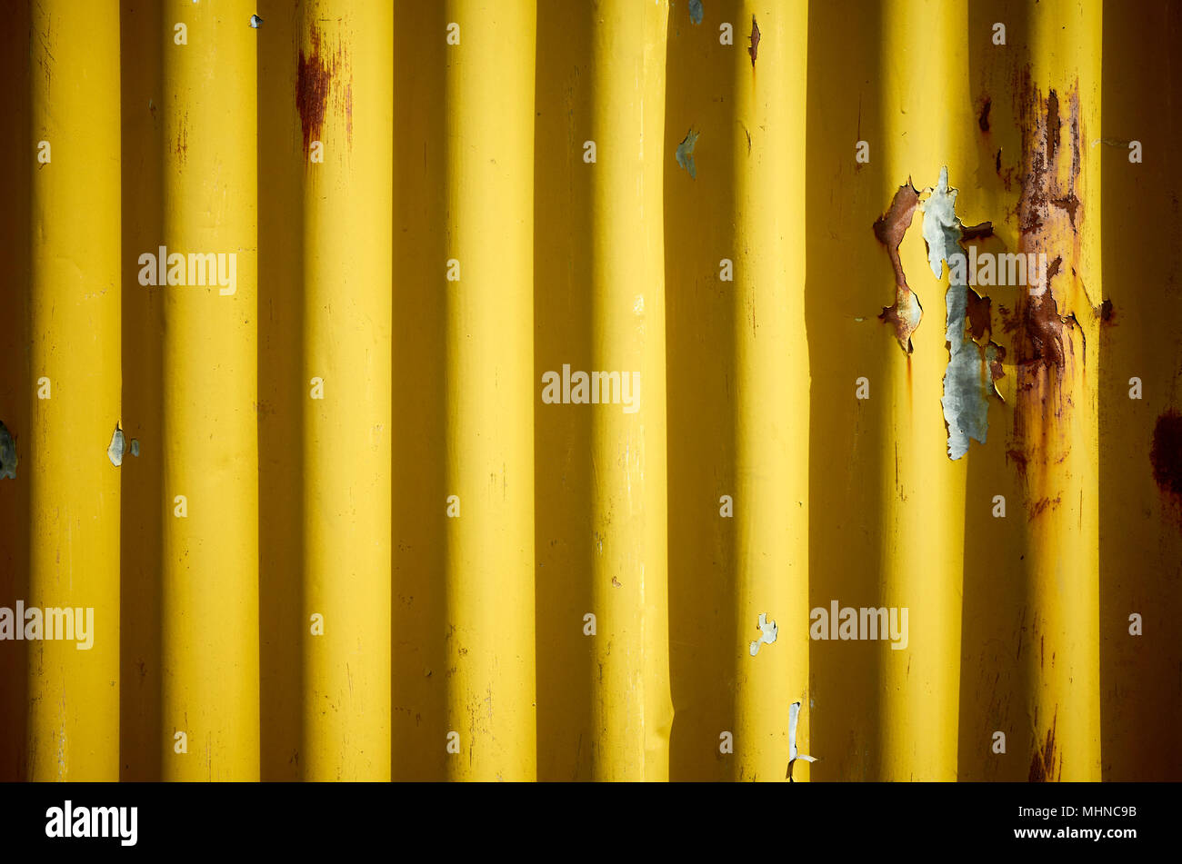Weathered corrugated yellow rusty metal wall, abstract background. Stock Photo