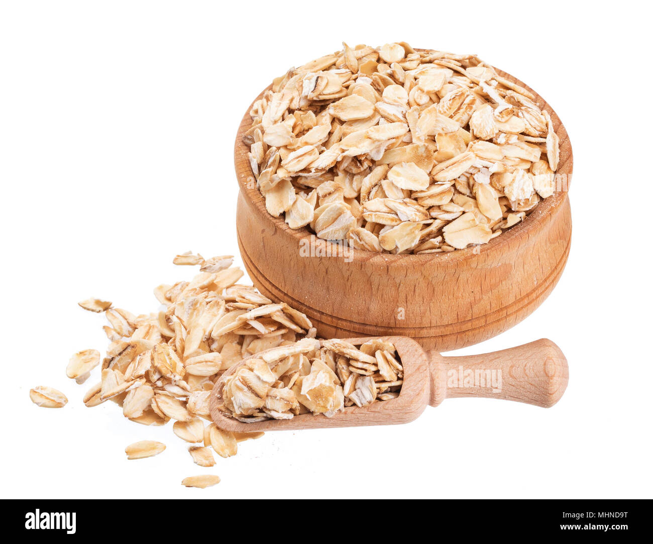 Isolated oat flakes. Wooden bowl and scoop with oatmeal on white background. Close-up Stock Photo