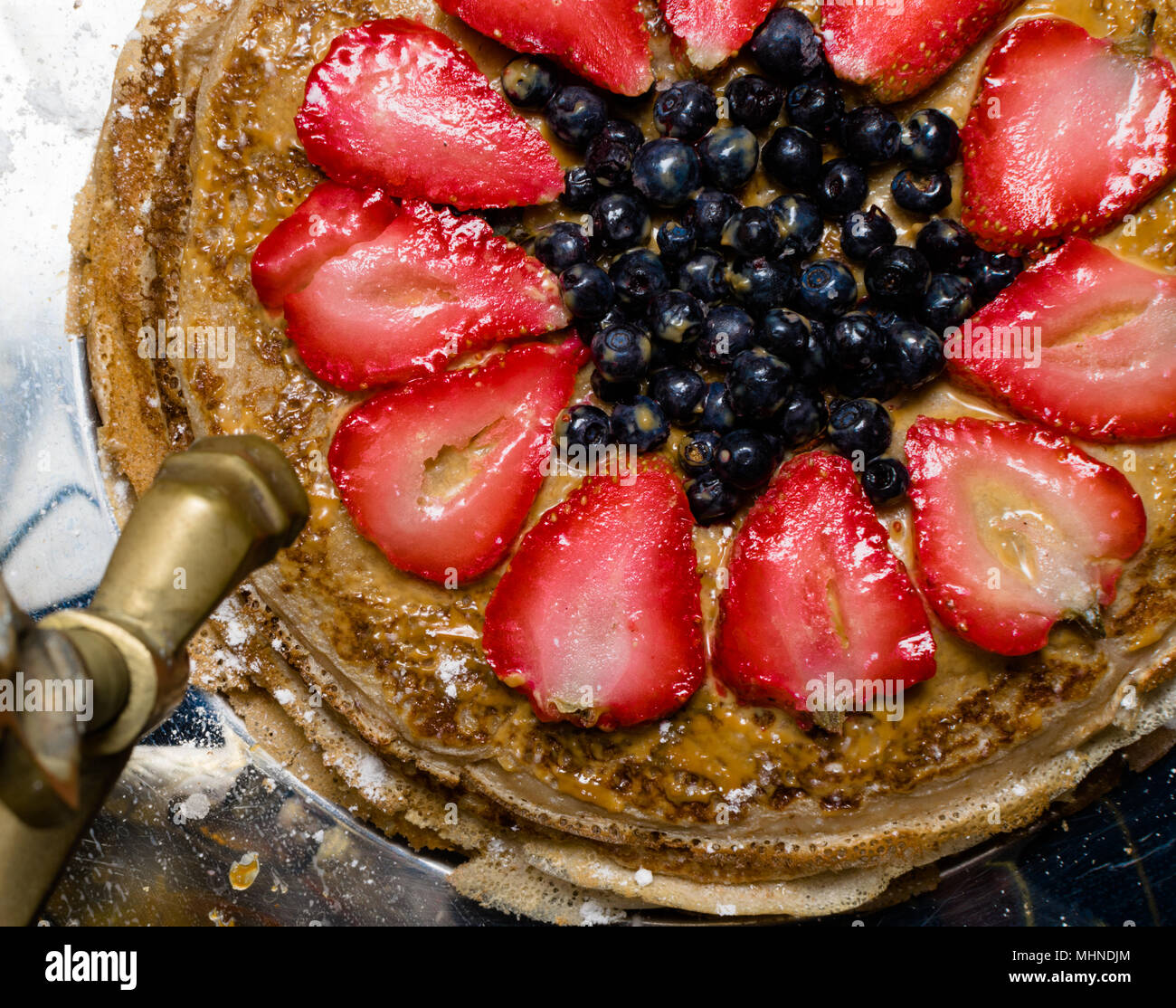 stack of freshly prepared traditional delicious pancakes cake with strawberries, blueberrys and