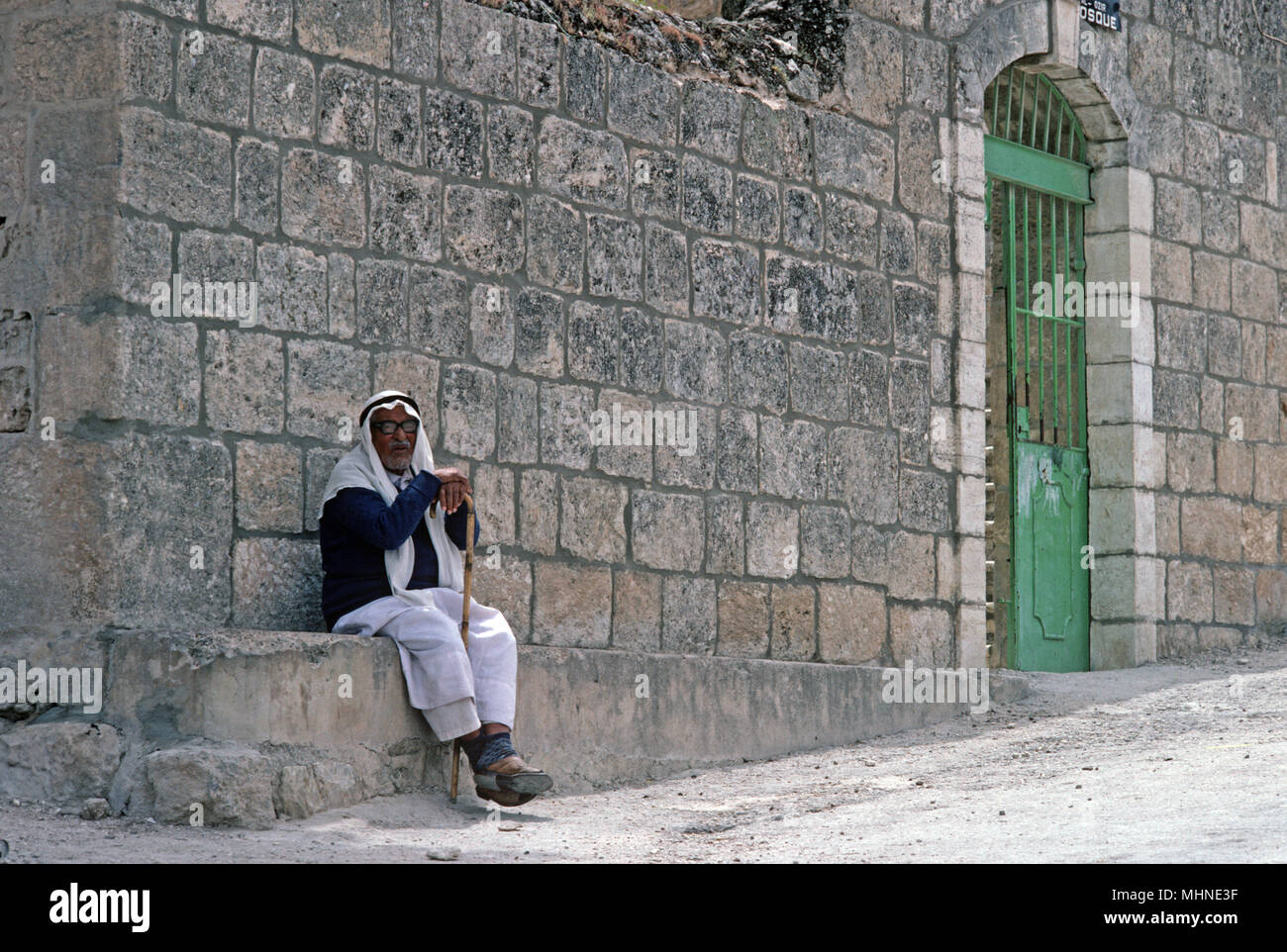 Palestinian man sitting in shade outside Mosque in Nazareth, West Bank, East Jerusalem, Israel