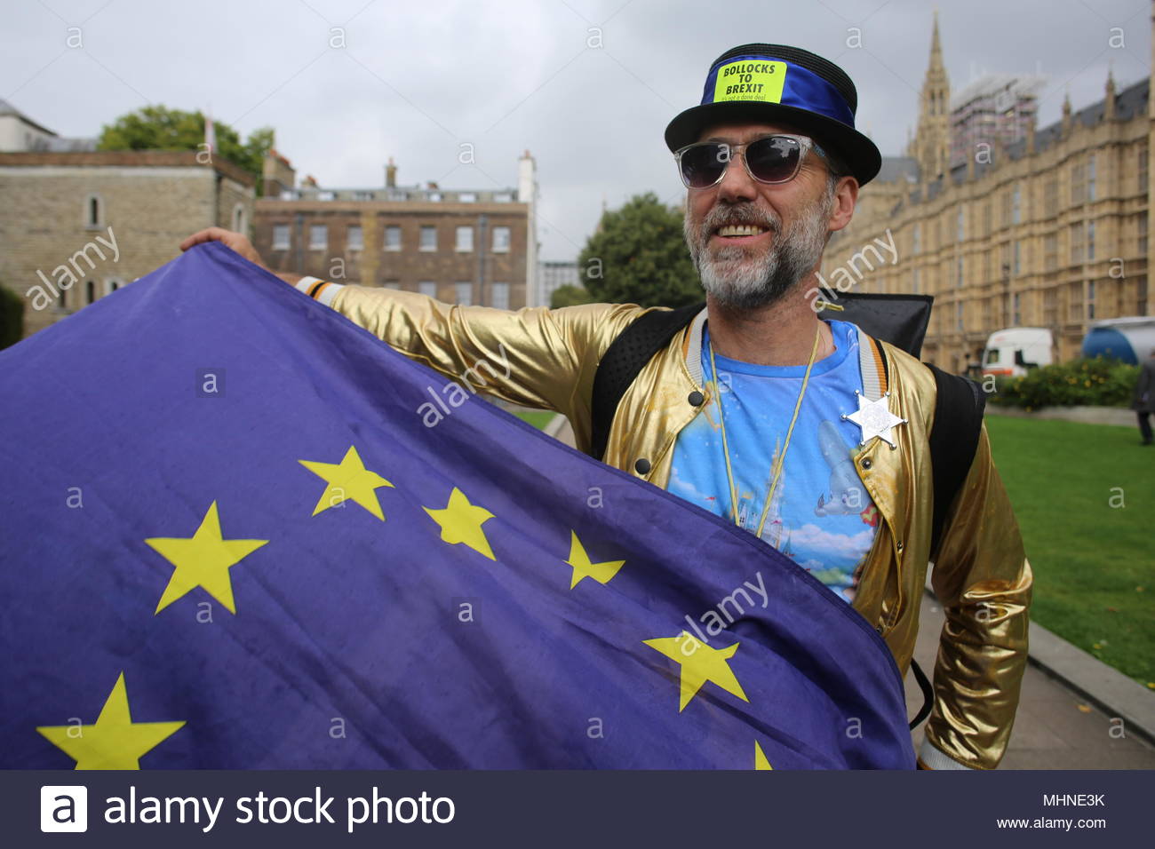 An anti-Brexit protestor waves the EU flag to photographers at Westminster with Big ben and the Palace of Westminster in the background. Stock Photo