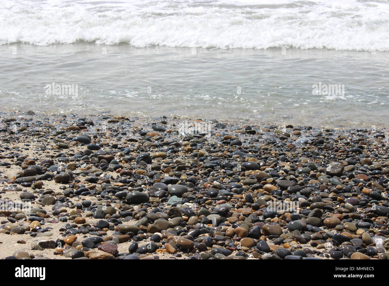 Waves Crashing Over Pebbles. Oceanside, CA Stock Photo