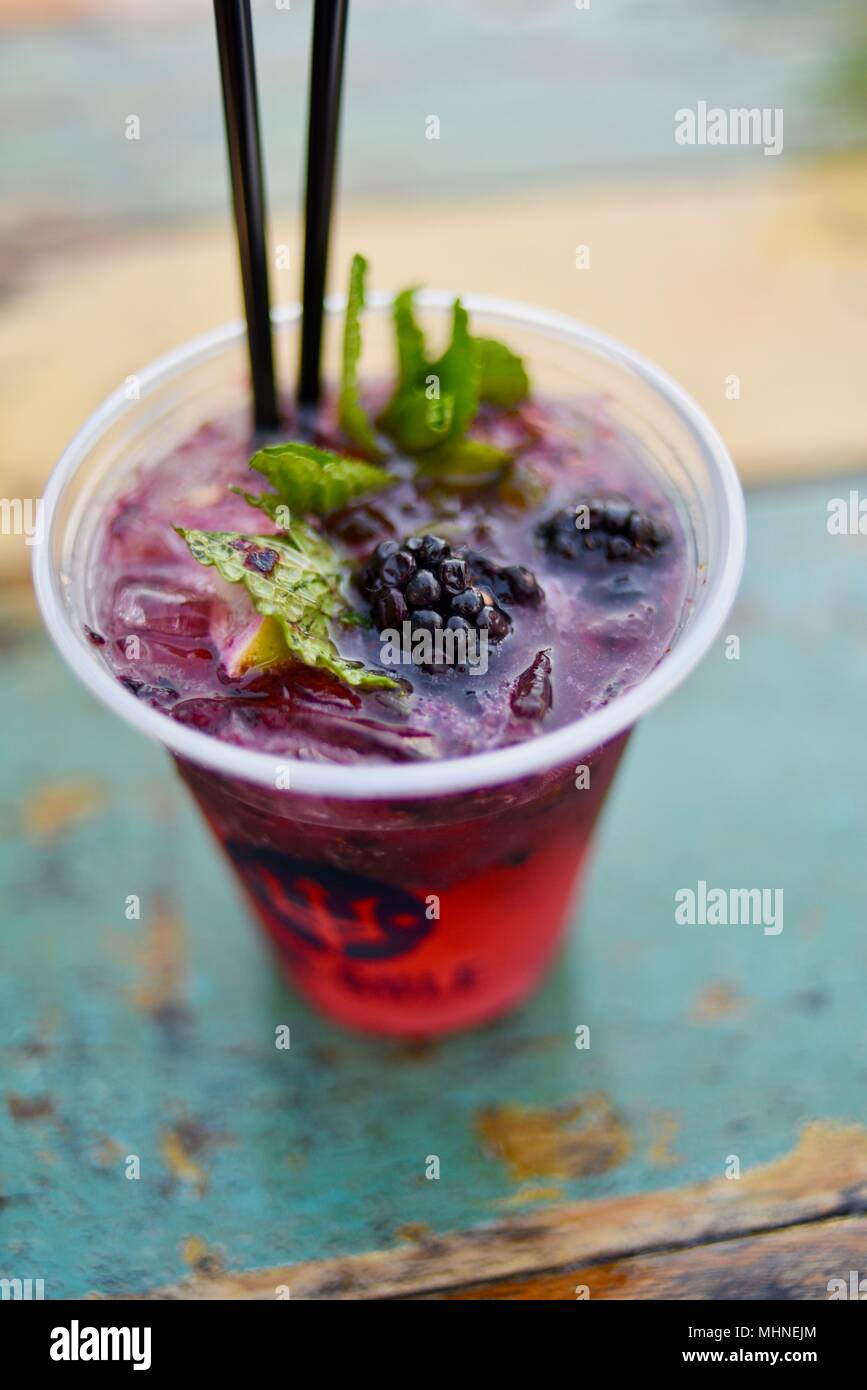 Signature blackberry mojito cocktail served at an outside table facing