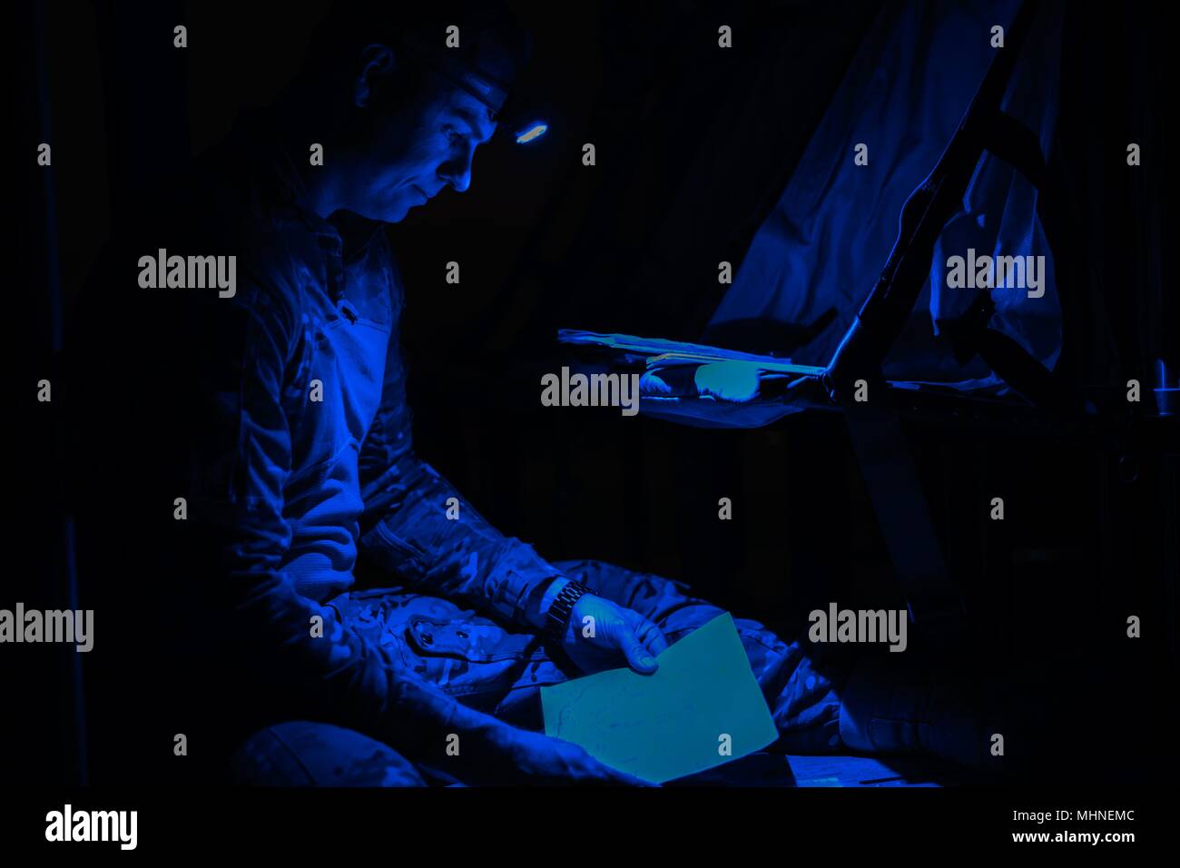 Chief Warrant Officer 2 Brandt Daniels, a UH-60 Blackhawk helicopter pilot with Company A, 3rd Assault Helicopter Battalion, 227th Aviation Regiment, 1st Air Cavalry Brigade, 1st Cavalry Division, prepares to conduct a crew brief prior to a night assault mission at Hohenfels Training Area, Germany, April 23, 2018, April 23, 2018. UH-60 Blackhawk helicopter flight crews of the battalion are participating in the U.S. Army Joint Modernization Command's Joint Warfighting Assessment 18, an exercise that increases training readiness, future force development and interoperability with NATO allies. (U Stock Photo