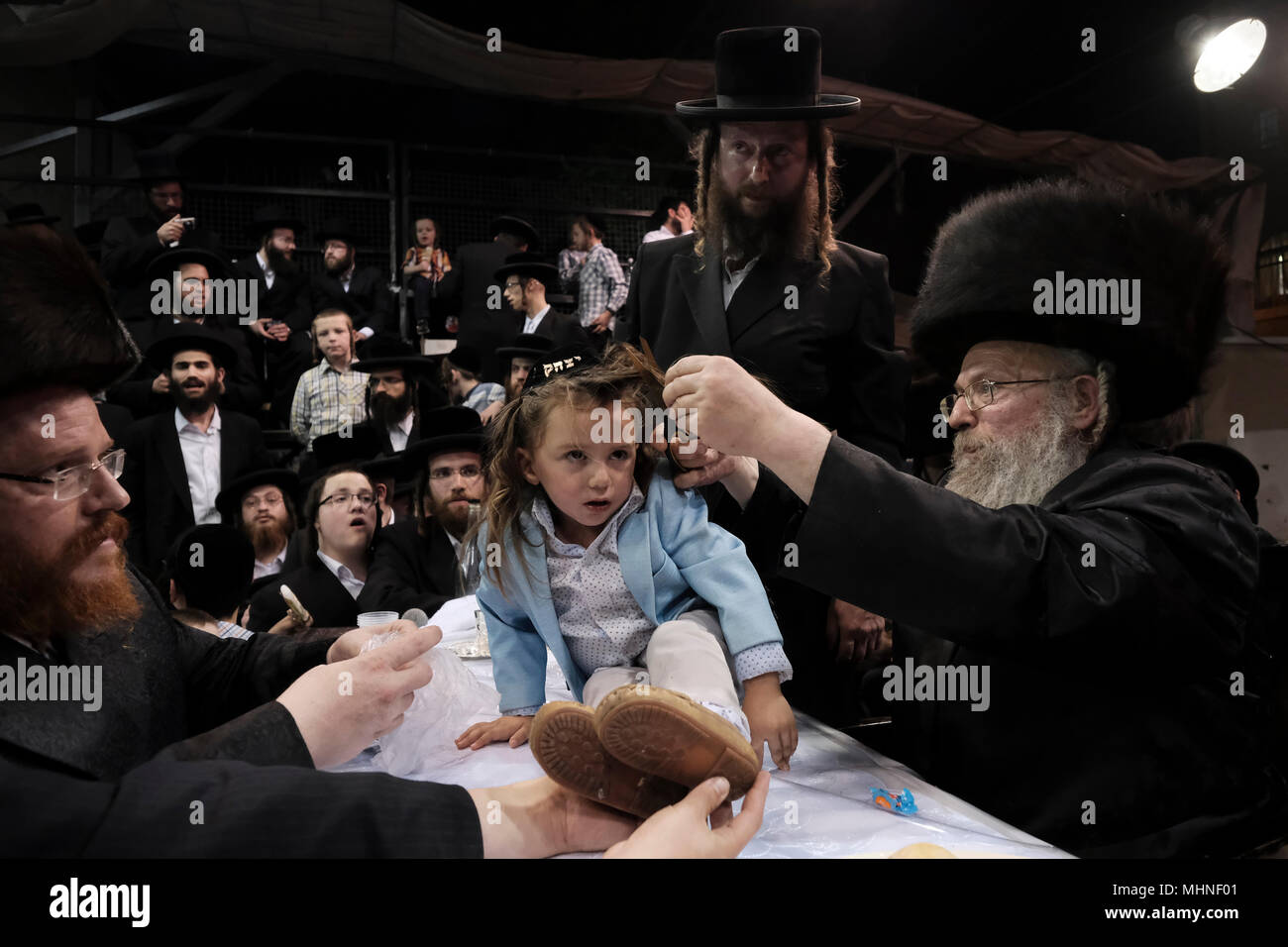 Jerusalem, Israel 02 May 2018. A three-year old Jewish boy takes part in the traditional Halake ceremony, a first hair cut from the Rabbi of the Pinsk-Karlin Hassidic dynasty in Geula religious neighborhood during the celebration of Lag BaOmer holiday which marks the celebration, interpreted by some as anniversary of death of Rabbi Shimon bar Yochai, one of Judaism's great sages some 1800 years ago and the day on which he revealed the deepest secrets of kabbalah a landmark text of Jewish mysticism Stock Photo