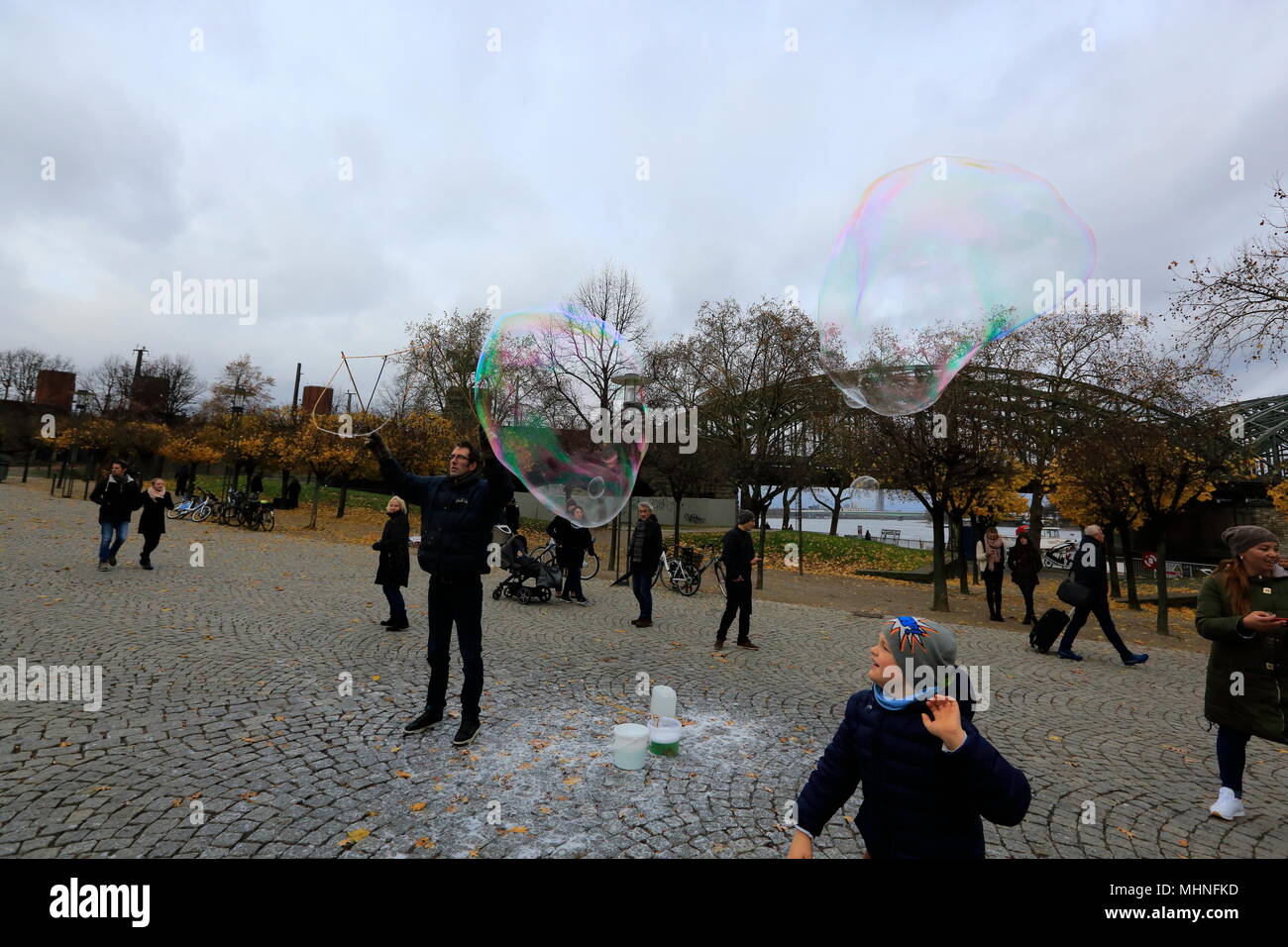 Tourists enjoying soap bubbles on the bank of Rhine River at Cologne, Northhine-Westfalia, Germany. Stock Photo