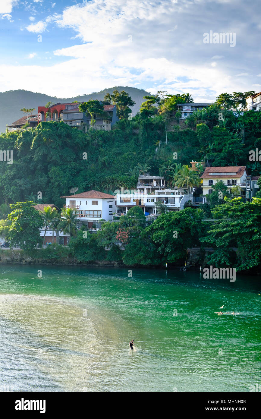 Marapendi Lagoon seen from above with houses on the hill during late afternoon. Barra da Tijuca, Rio de Janeiro. Stock Photo