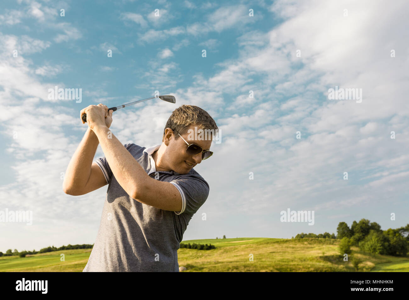 Close up of young man swinging a golf club Stock Photo