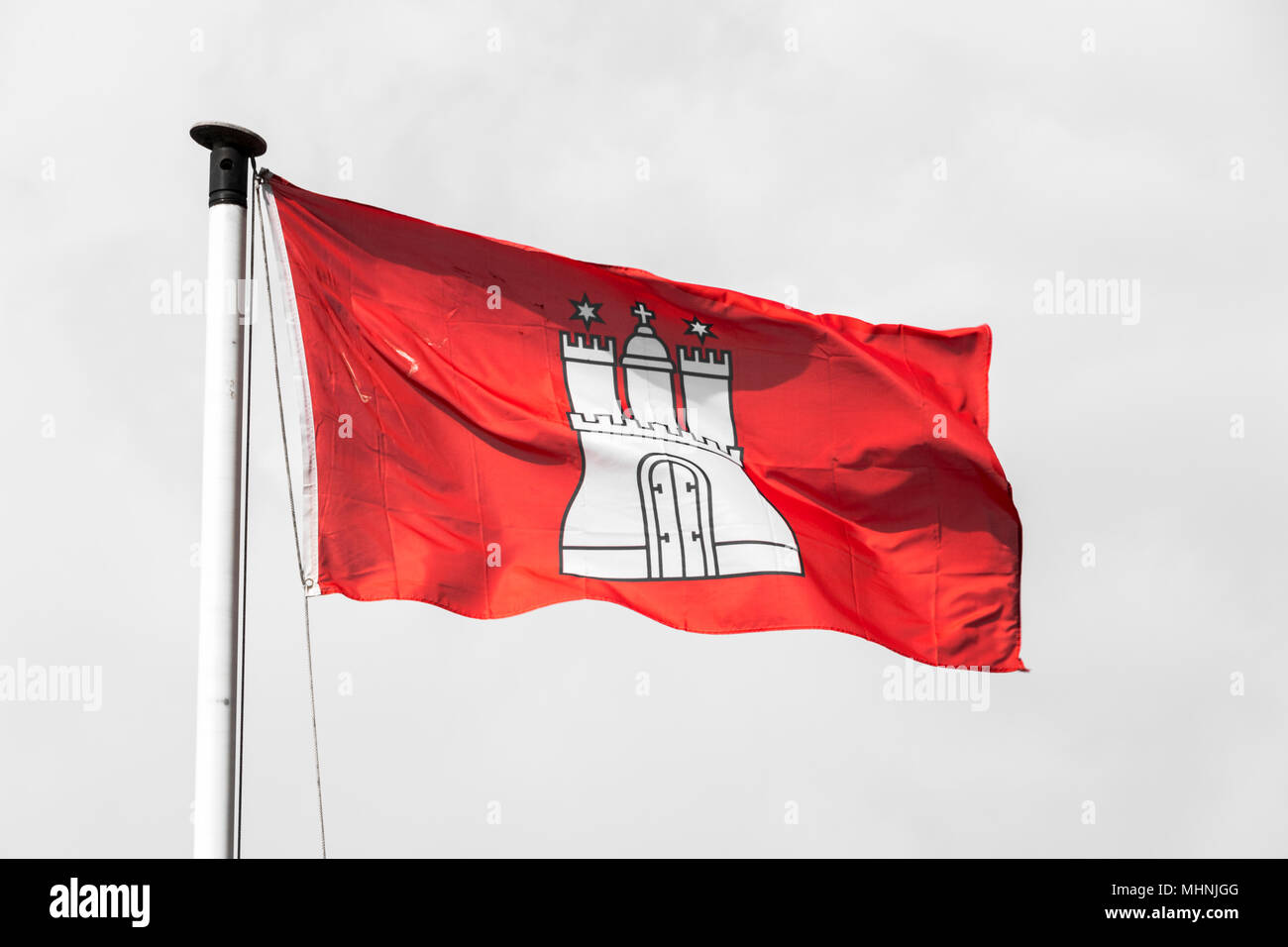Civil and state flag of the Free and Hanseatic City of Hamburg, with the coat of arms showing a white castle with three towers on a red background Stock Photo