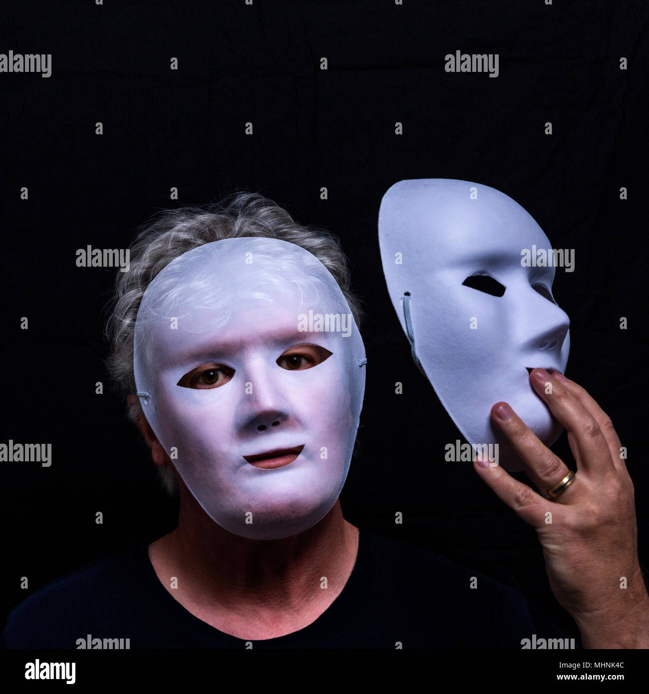 Masked man, double exposure with mask in hand and facial features partly  appearing through mask on face Stock Photo - Alamy