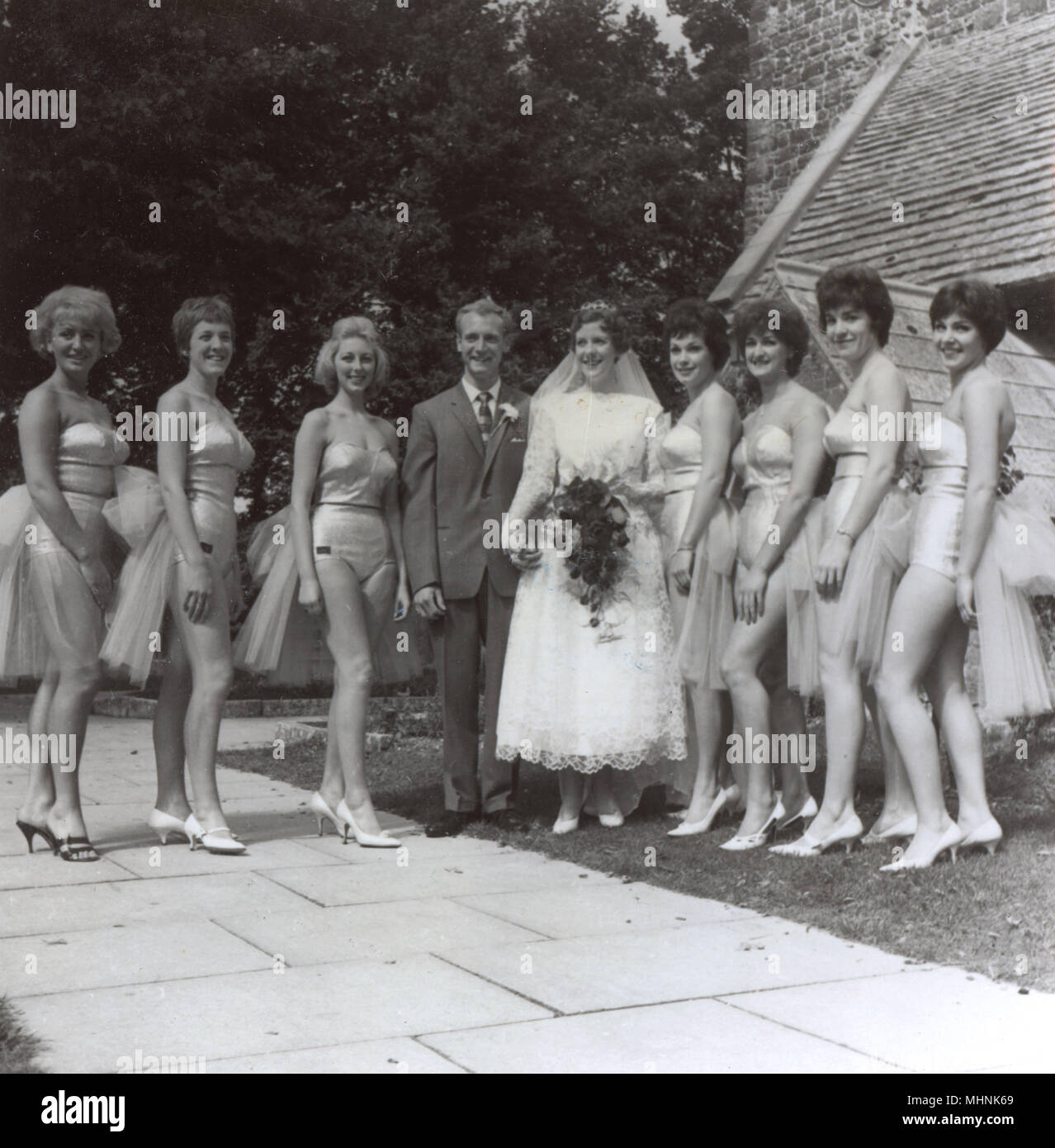 August 1962, Kinson, Bournemouth. The wedding of Eileen Hart, 22 of New Milton and David King of Coombe Gardens, Bournemouth caused quite a stir (and claims of a publicity stunt) in the local press (and rather a lot of 'tutting' it seems) when seven of Hart's teammates from the Bournemouth Aqua Theatre's 'Big Splash' summer show posed for the wedding photographs outside the church in their swimsuits. The General Manager of the Pier Approach Baths apologised to the Vicar of St. Andrew's Church (the Rev. Alfred Loughlin) on behalf of the Baths Committee. The whole incident was closed amicably - Stock Photo