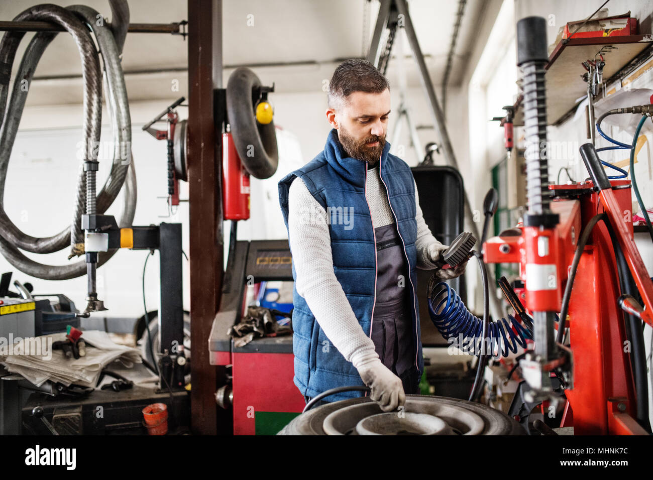 Man mechanic repairing a car in a garage Stock Photo - Alamy