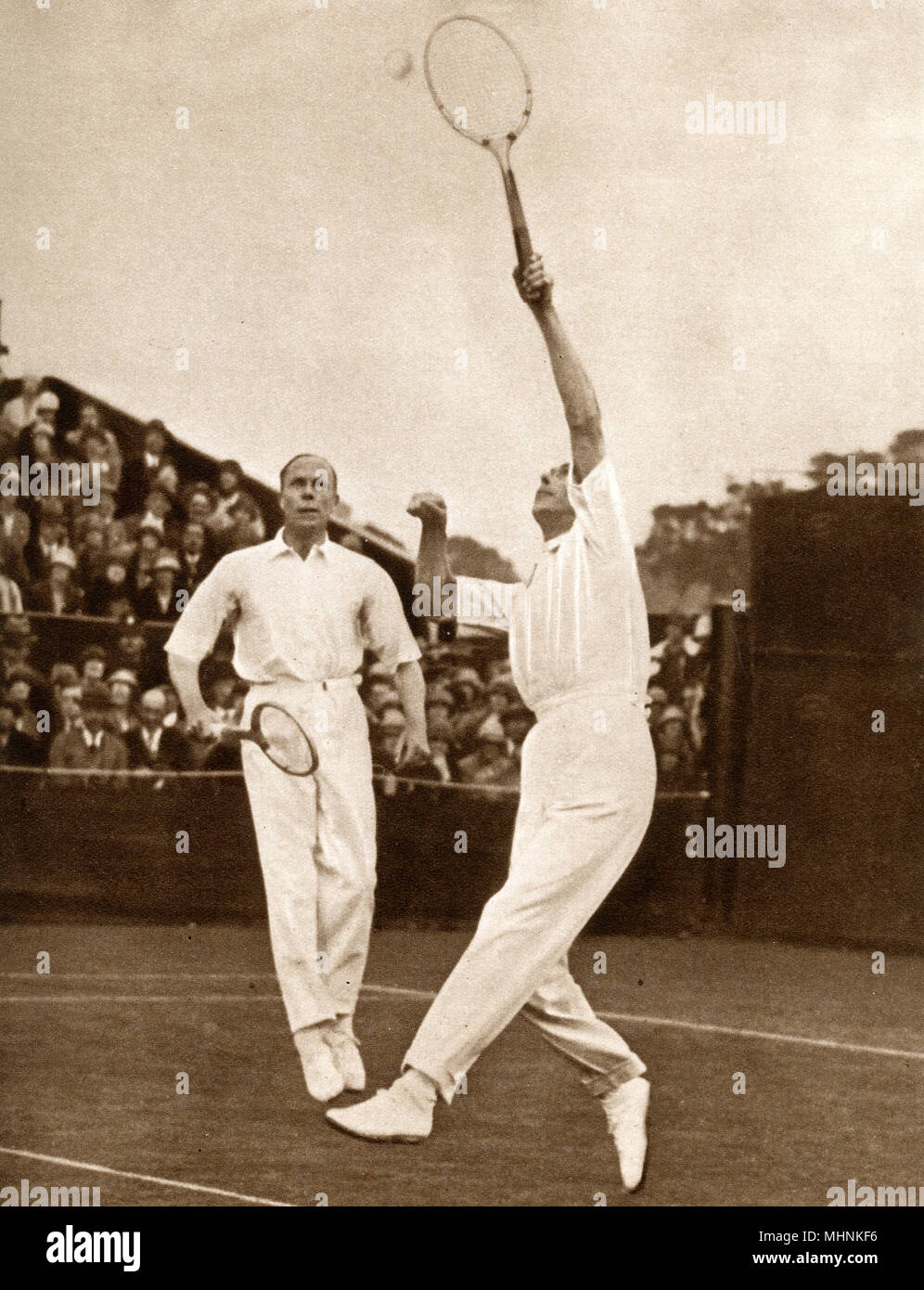 Duke of York competing in the Men's Doubles at Wimbledon with Wing-Commander Louis Grieg. They lost to the wily veterans (who were both over 50!) Arthur W. Gore and Herbert Roper Barrett, who won 6-1, 6-3, 6-2. here the Dukes smashes back a high return.     Date: 1926 Stock Photo