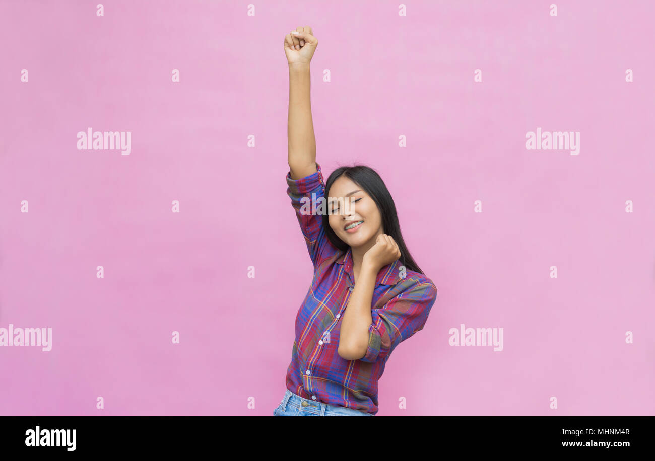 Portrait of a joyful happy teenage girl celebrating success while dancing isolated on pink background Stock Photo