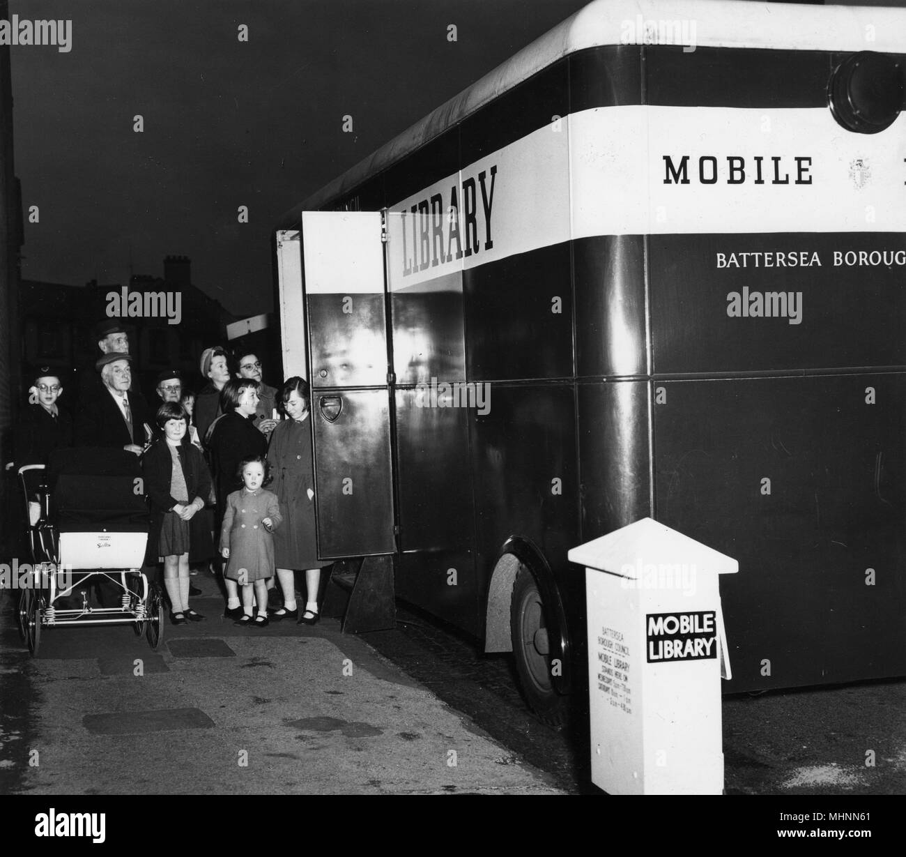 Enthusiastic bookworms line up to enter Battersea mobile library.     Date: 1950s Stock Photo