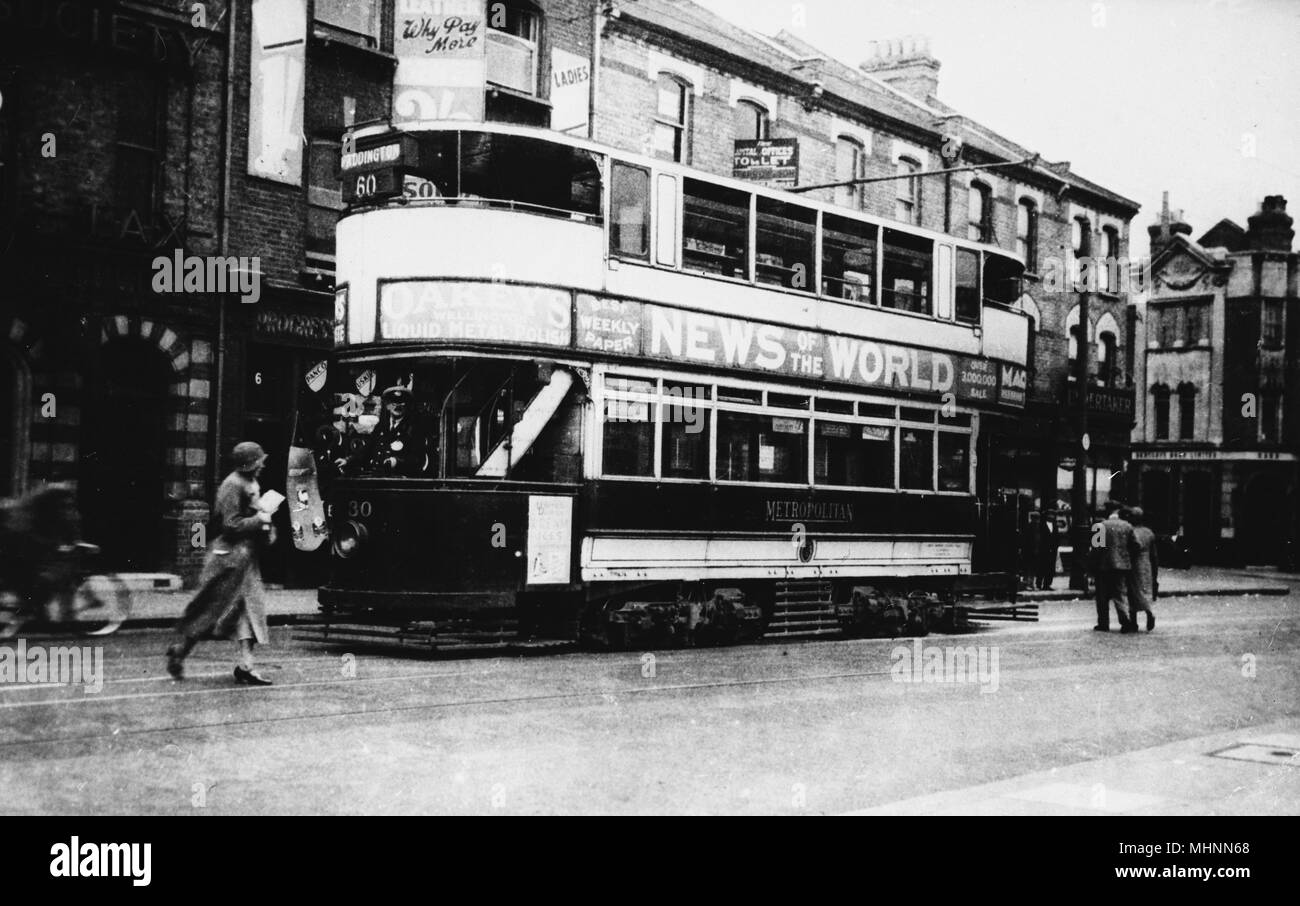 Harrow Road tram on Route 60 going to Paddington, advertising The News of the World newspaper.      Date: circa 1920s Stock Photo