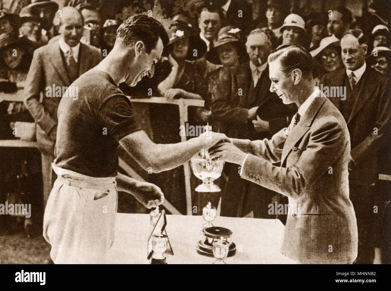 Albert, Duke of York (later King George VI 1895-1952) pictured awarding the Duke of York's Cup to his cousin and Captain of the victorious Navy team, Lord Louis Mountbatten (1st Earl Mountbatten of Burma 1900-1979) at the annual polo match between the Royal Air Force and the Royal Navy at Ranelagh in July, 1933.     Date: 1933 Stock Photo